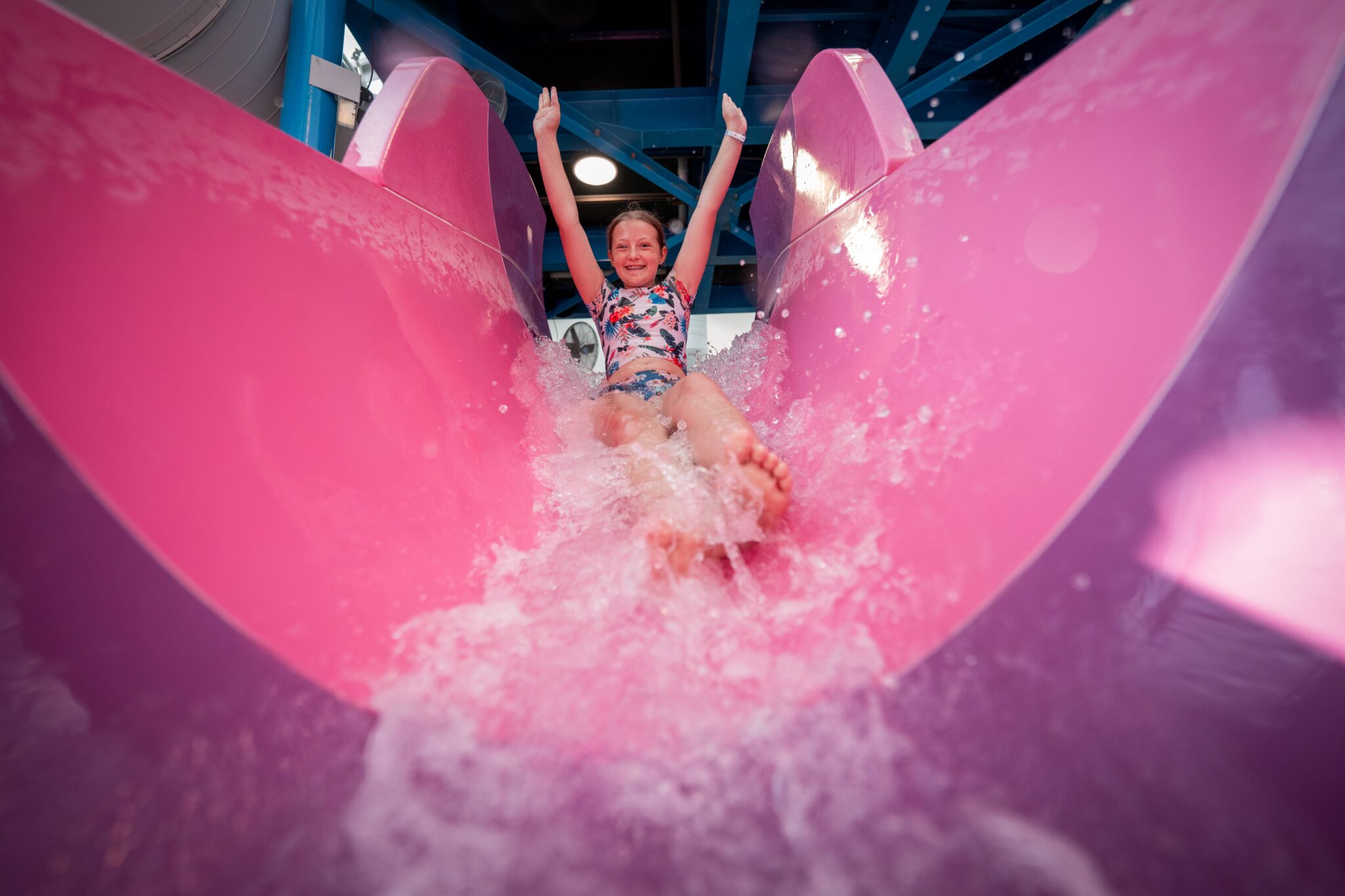 A girl going down a pink water slide