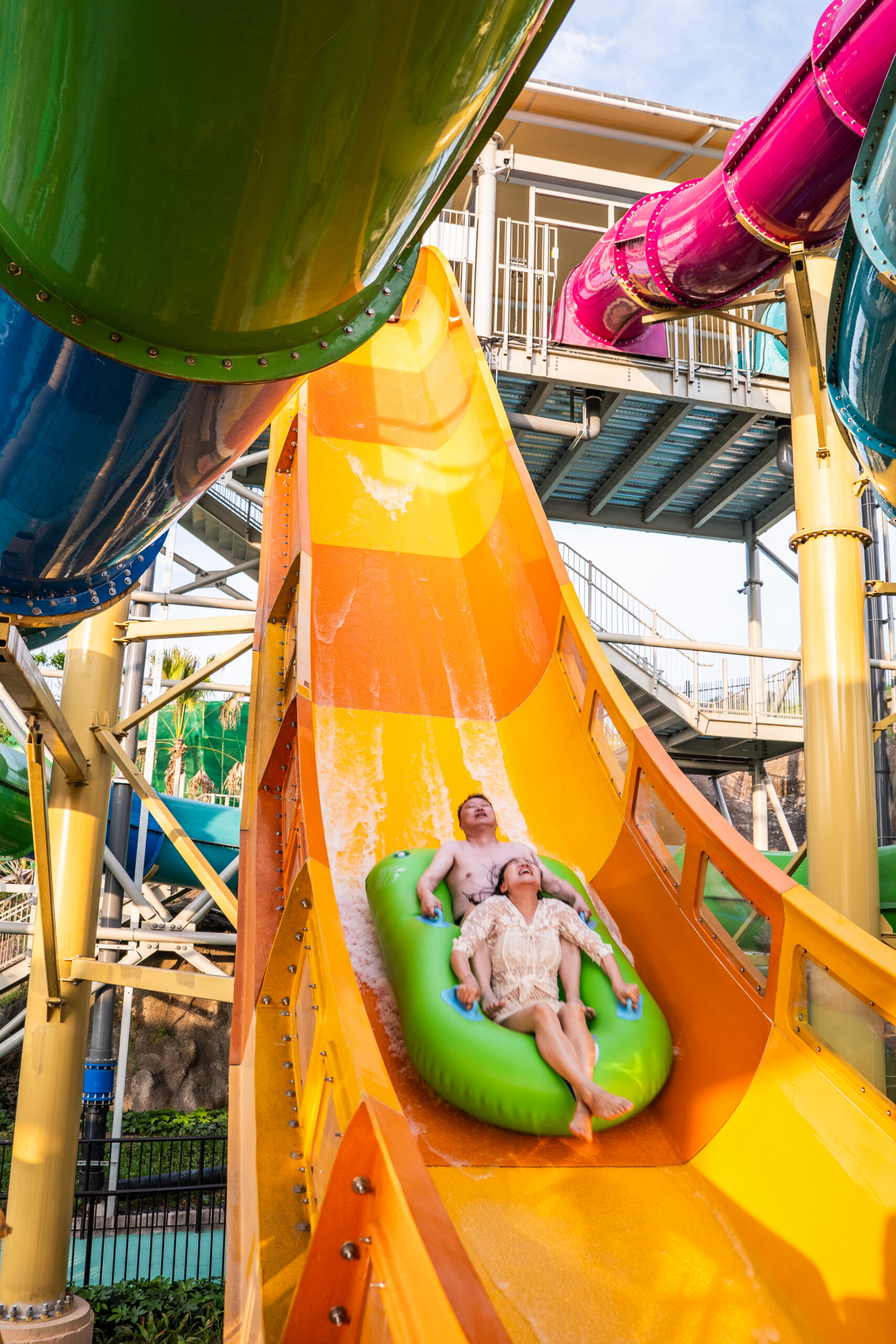 Riders in an inner tube going down an orange water coaster