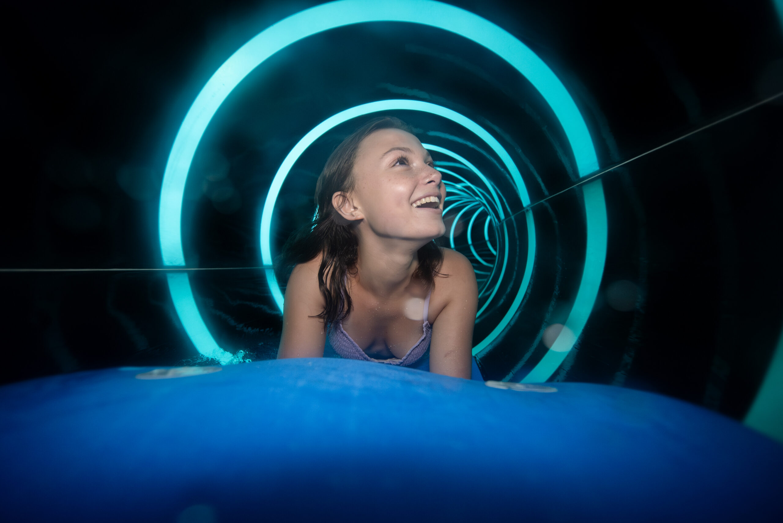 A woman on a mat through a water slide
