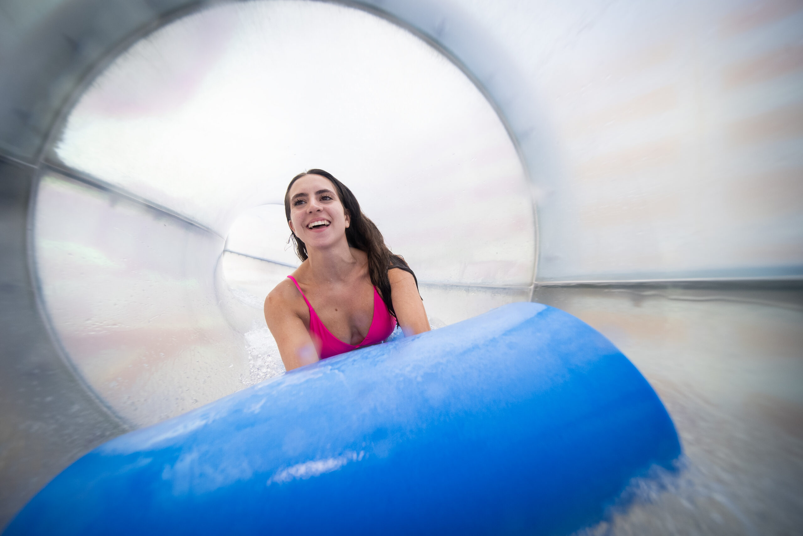 Woman on a mat inside a water slide flume