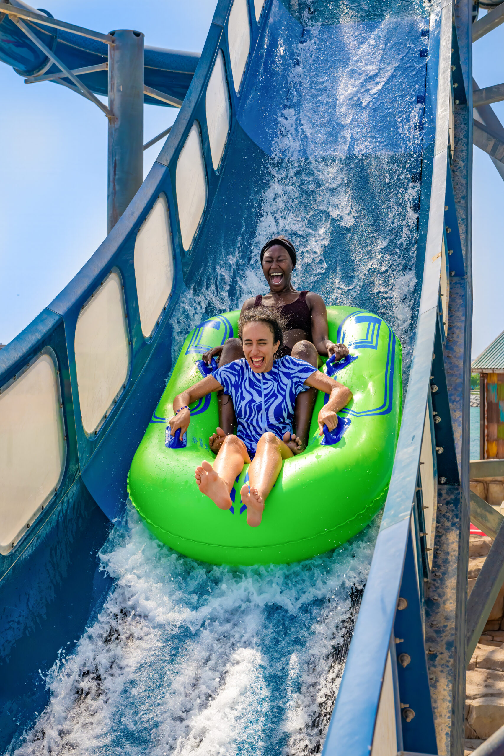 Two girls on an inner tube down a water slide