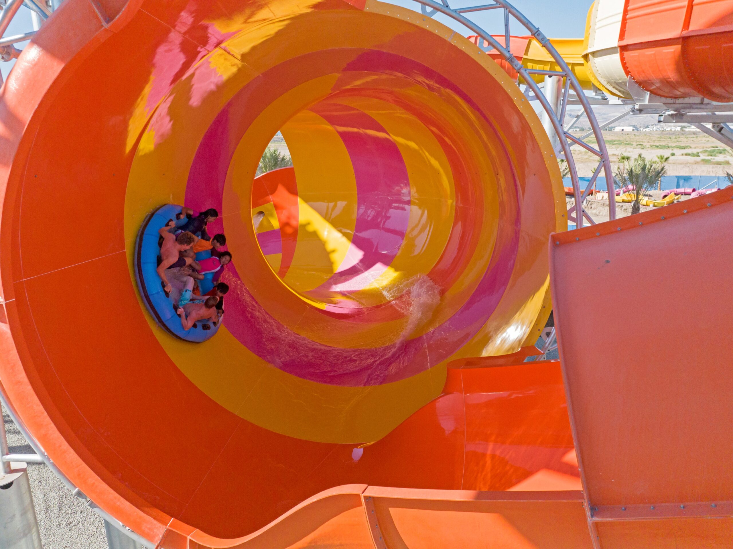 Huge yellow and orange water slide flume with a raft inside