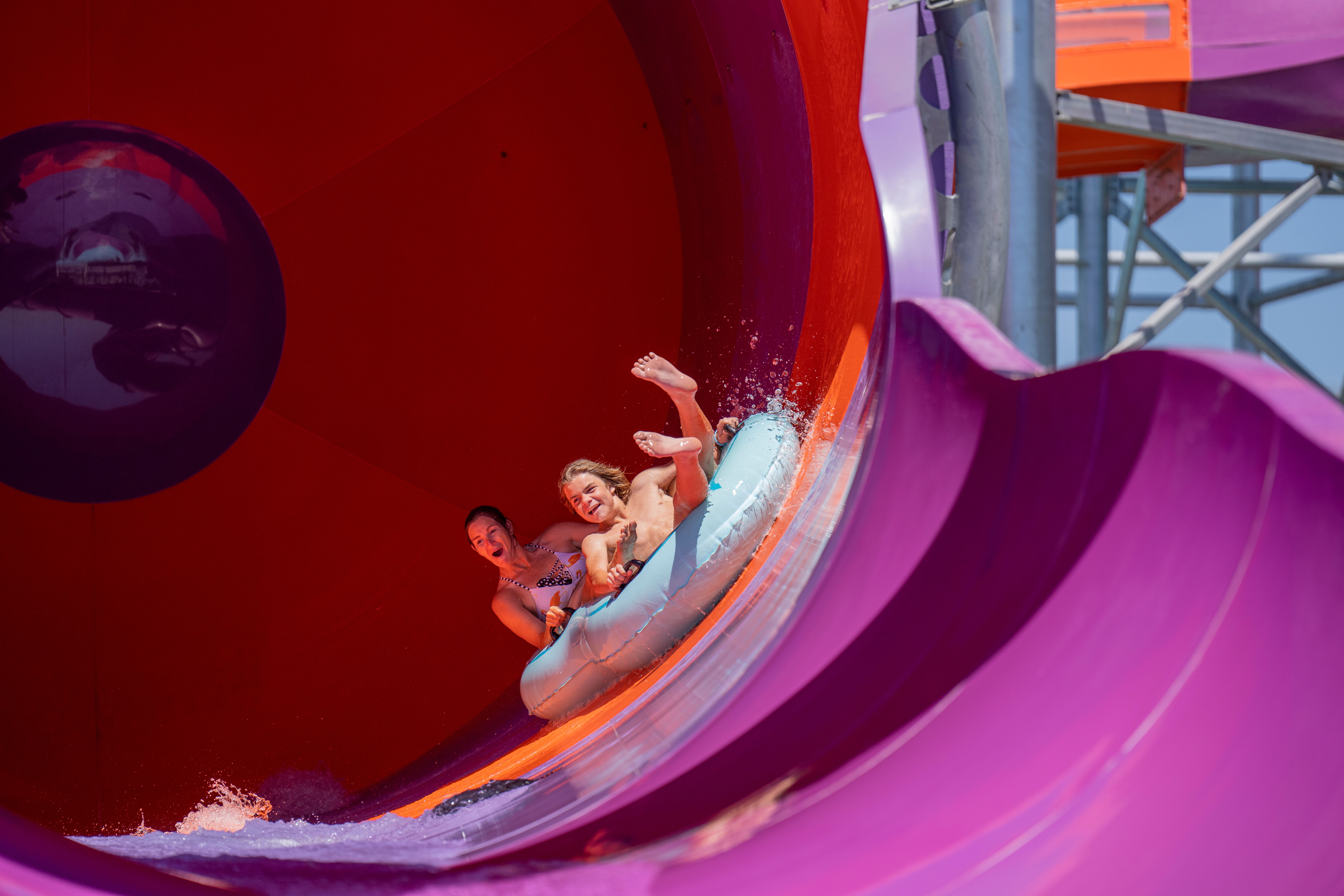 Riders in an inner tube slide