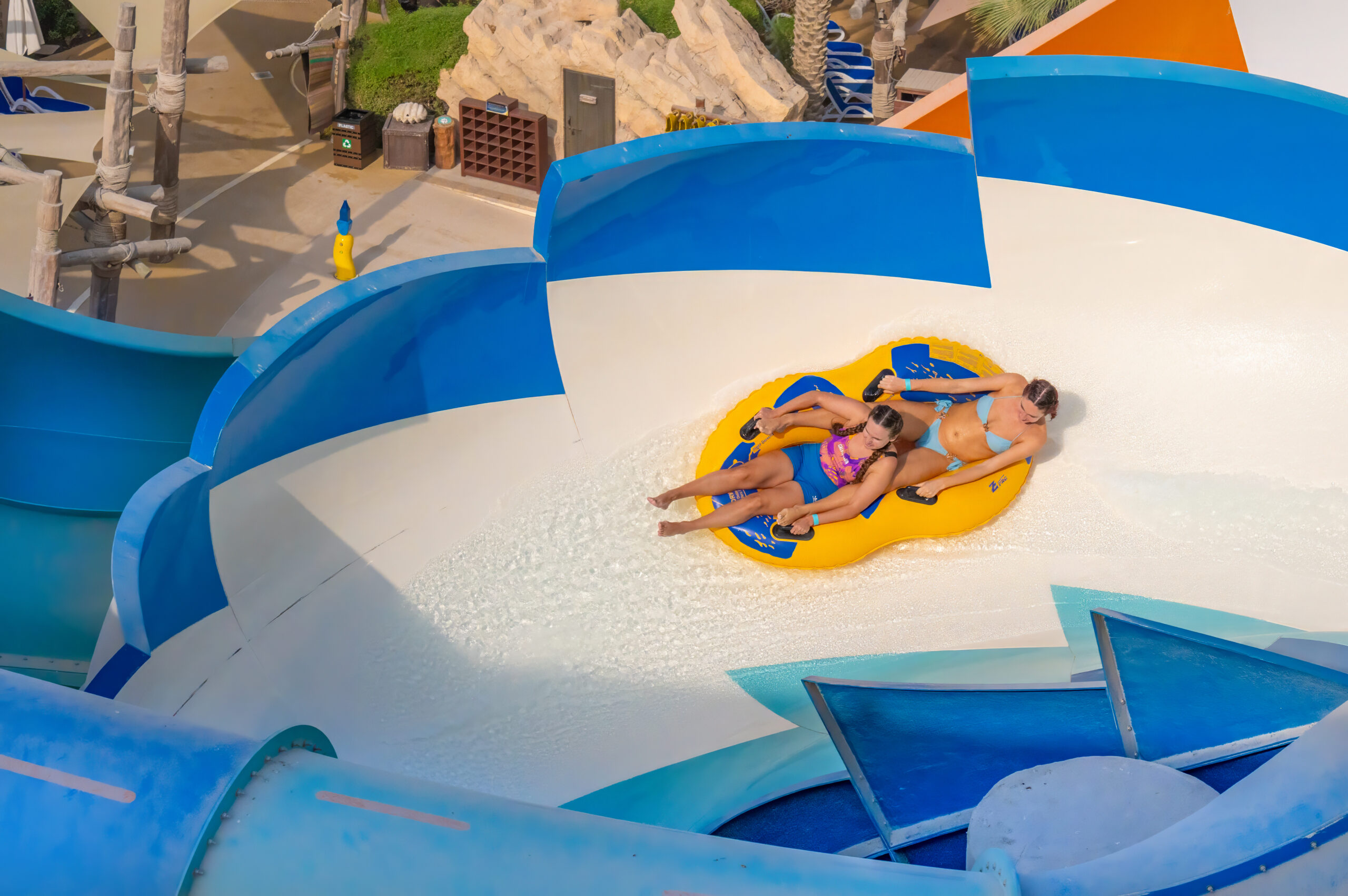 Two people in an inner tube water slide