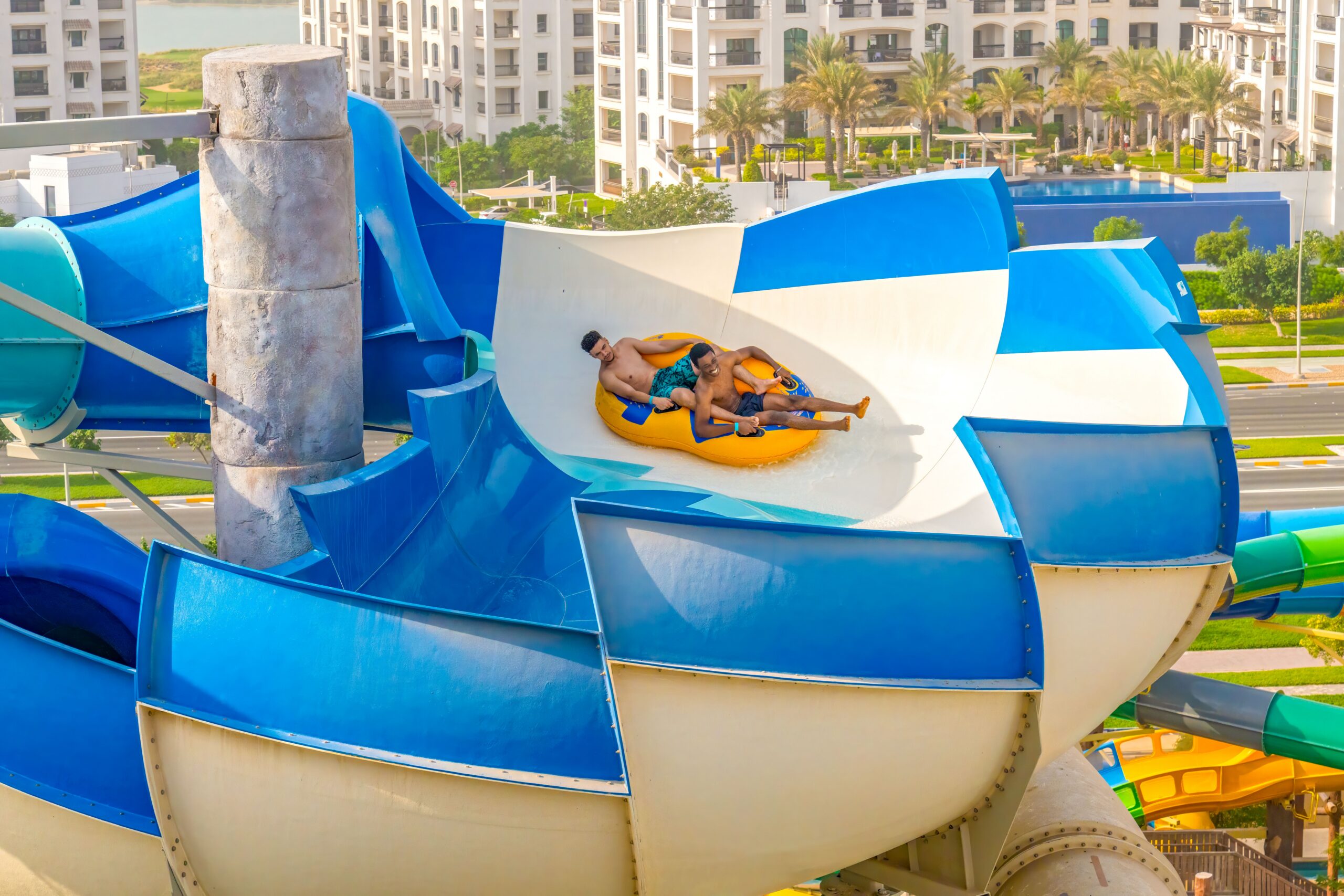 Two men in an inner tube in a bowl-like water slide