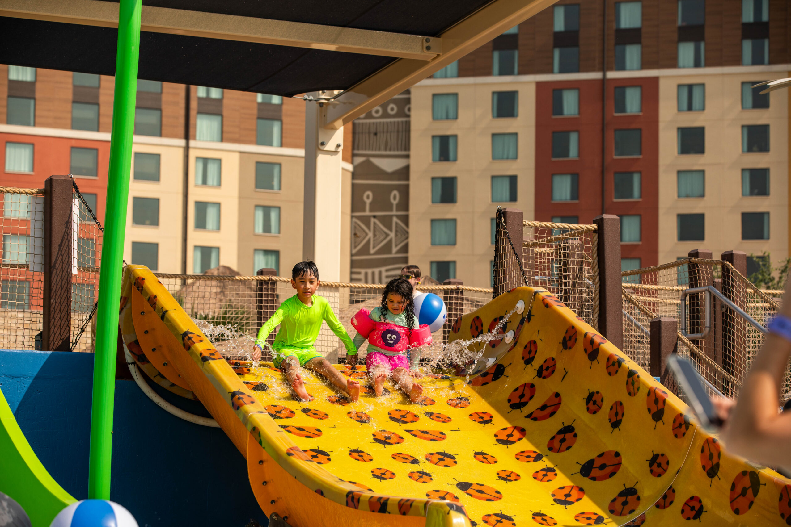 Small children on a ramp slide at a hotel