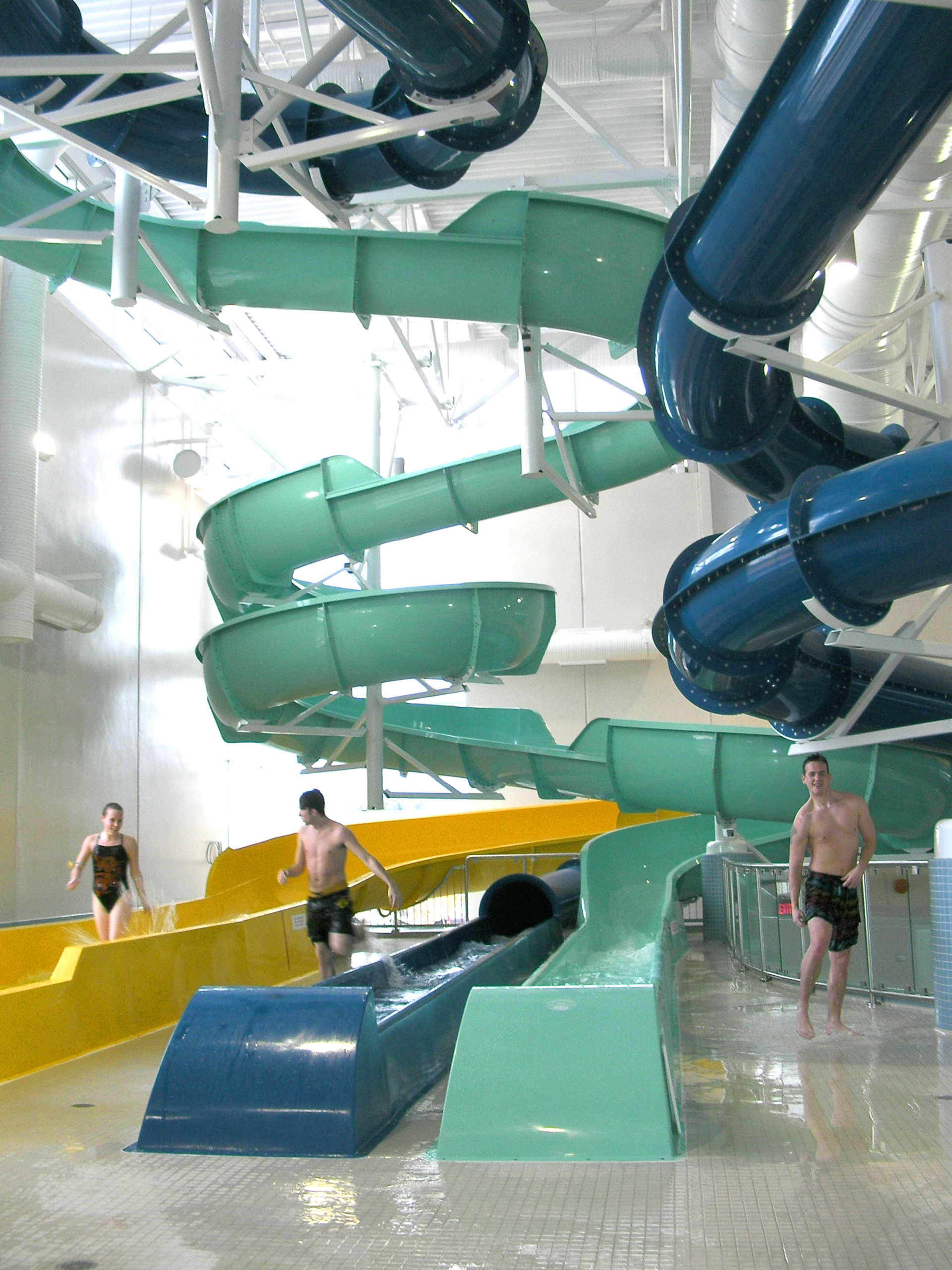 Three young people have just finished their ride on the spinning slide