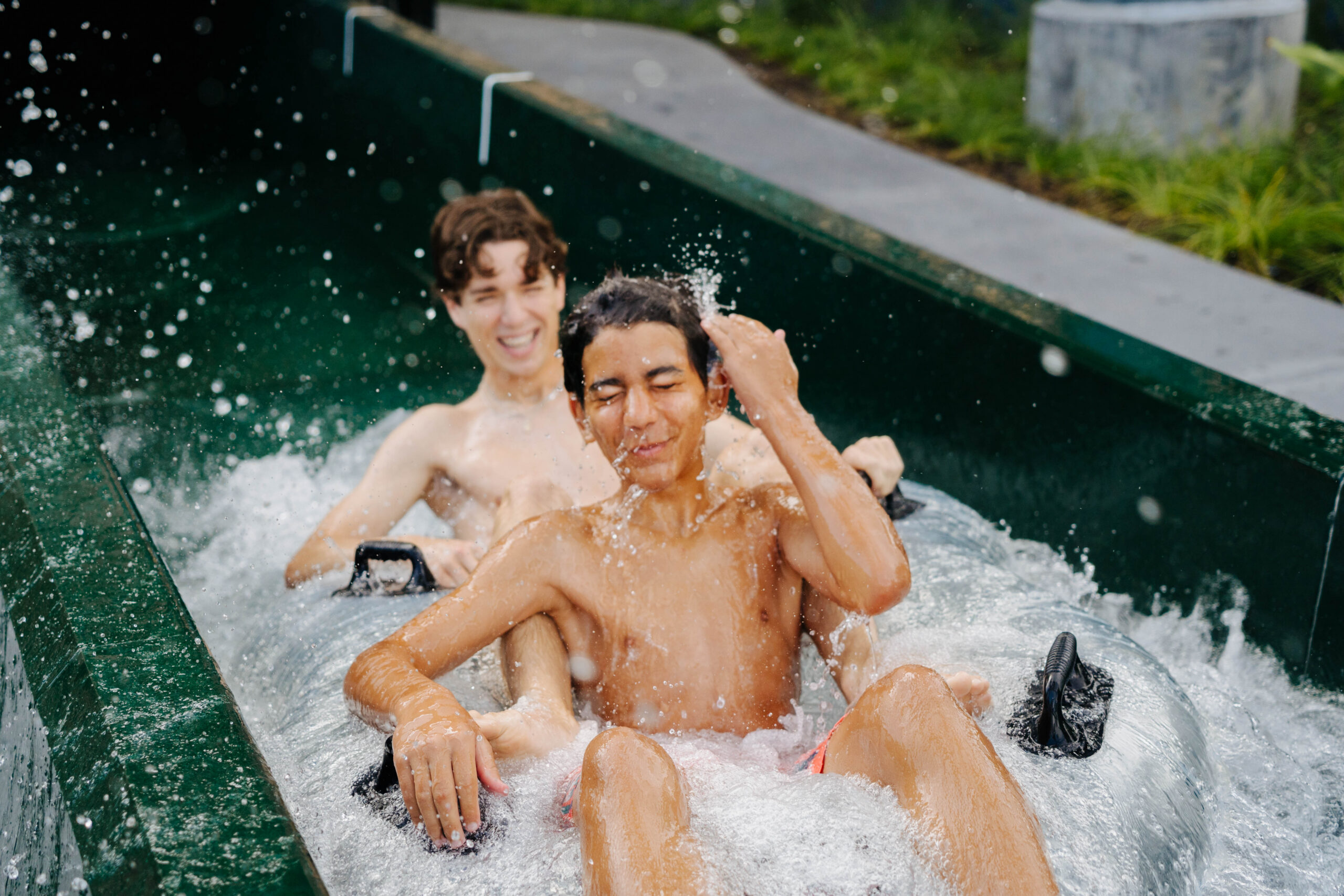 Two boys in an inner tube in a water slide runout lane