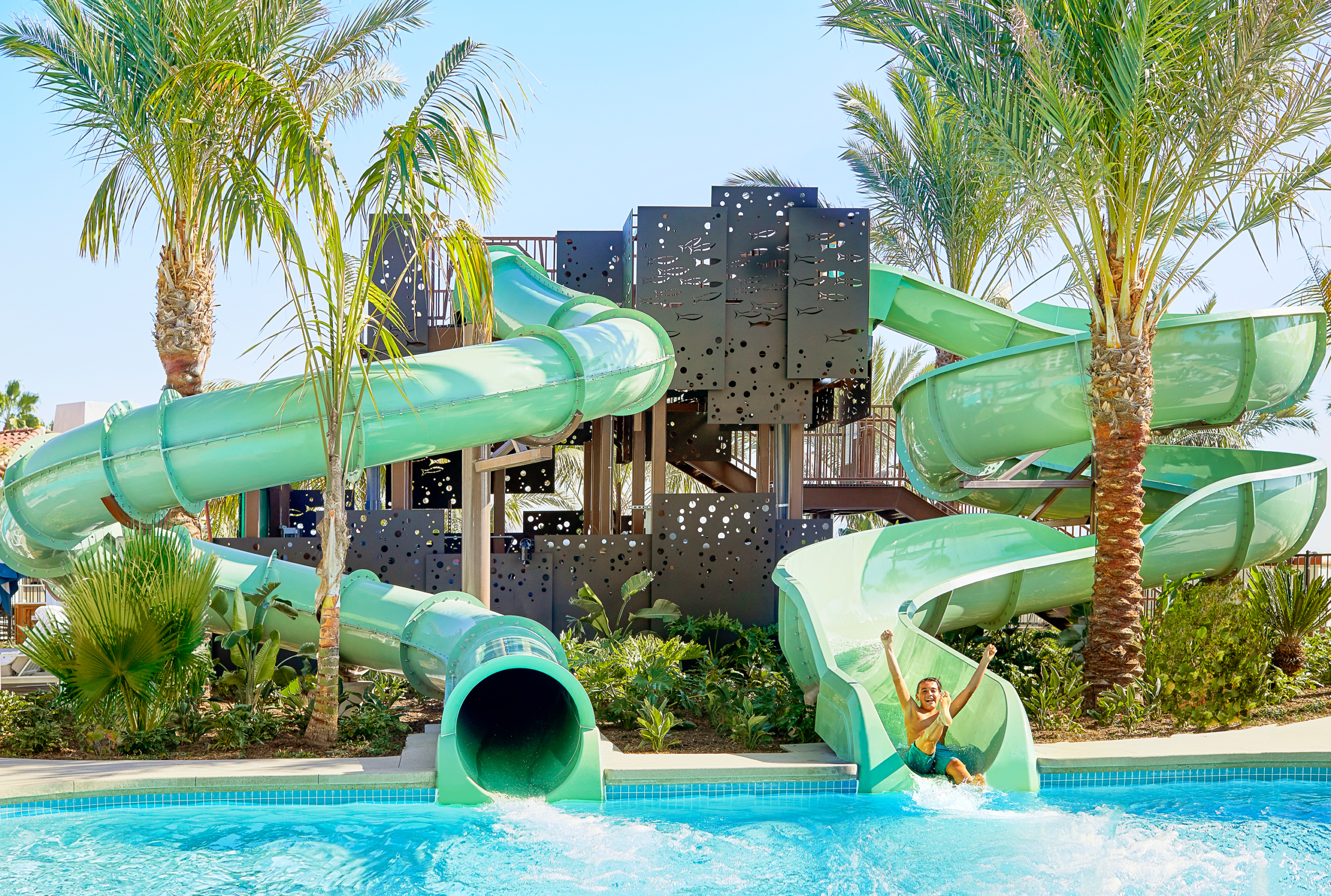 A child cheers before sliding into the water