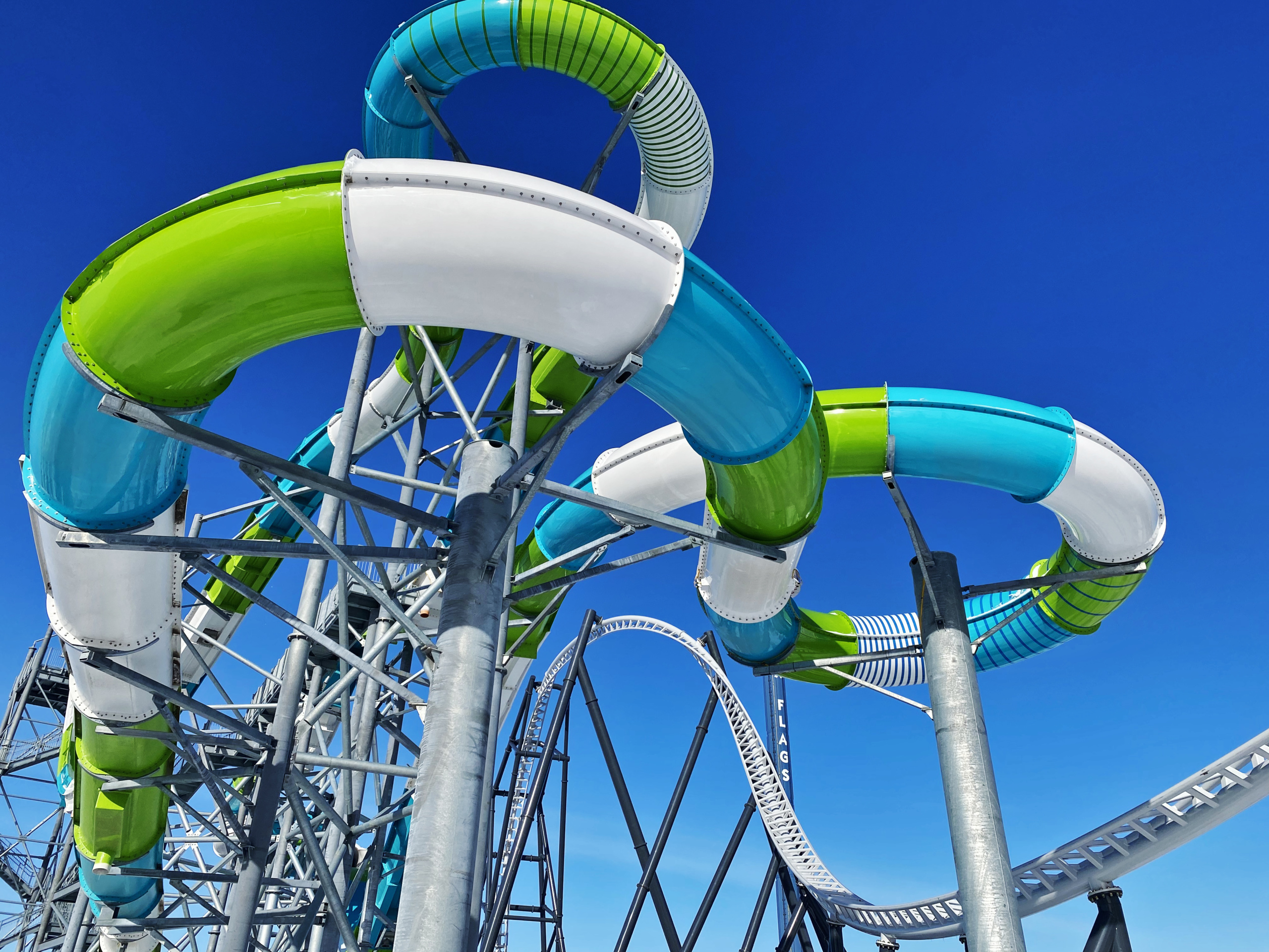 Looking up at outer view of Tsunami Surge water coaster with roller coaster