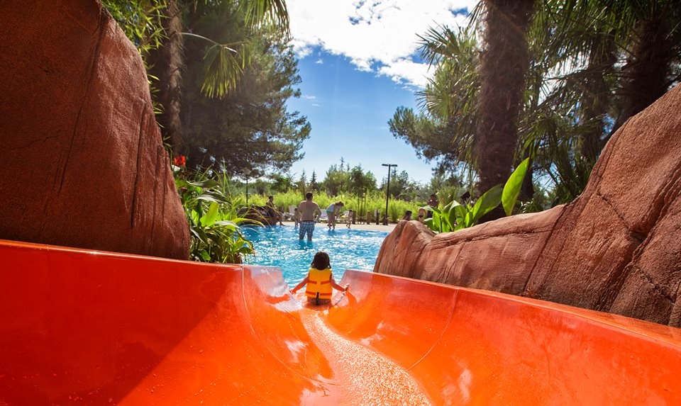 Child going down a water slide in a scenic water park