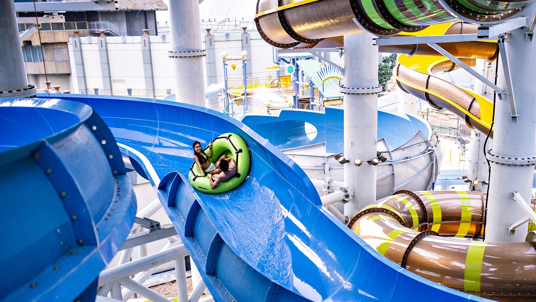 Family raft ride going down blue water slide