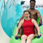 Man and woman sliding down water coaster