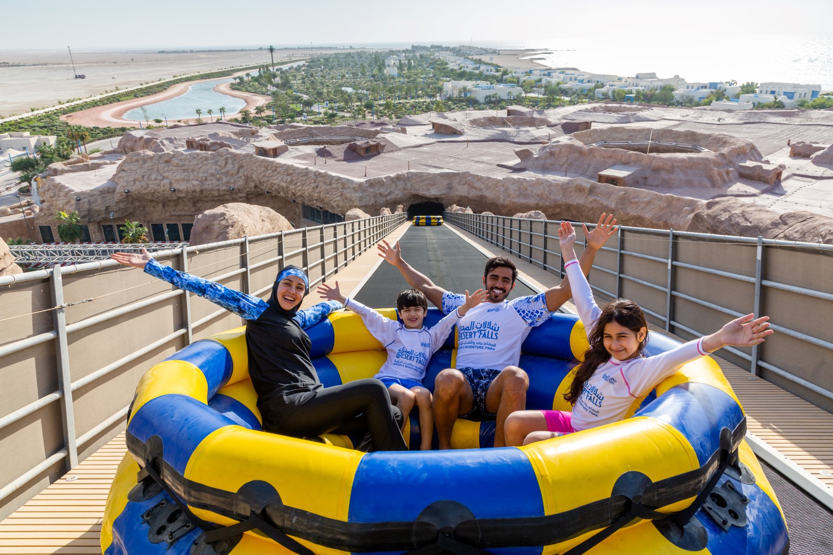A Middle Eastern family of four on the conveyor of a Spinning Rapids Ride in Qatar