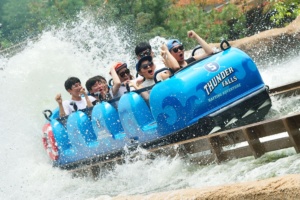 people on blue super flume water ride with splash