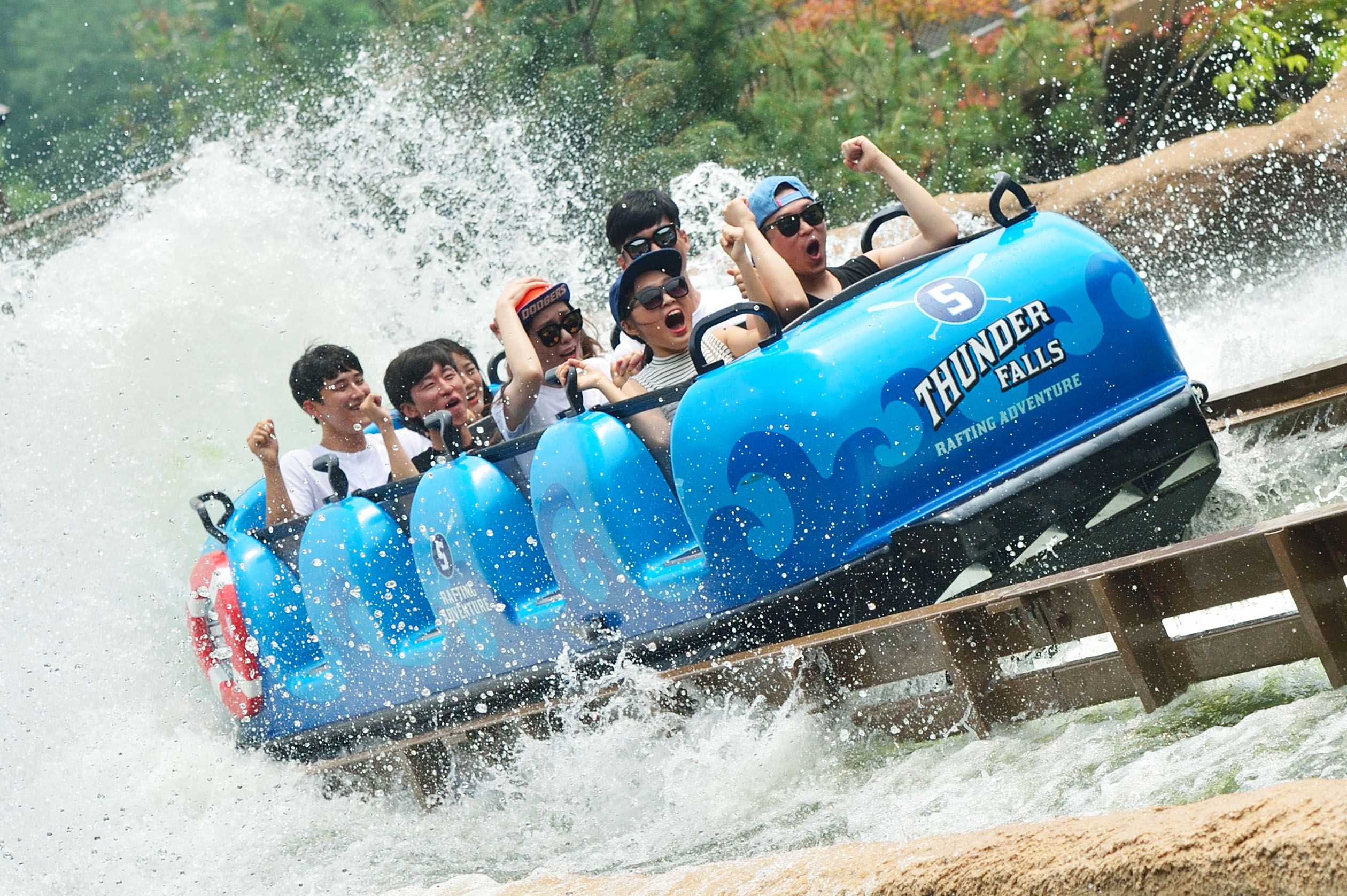 Guests riding blue Super Flume with splash