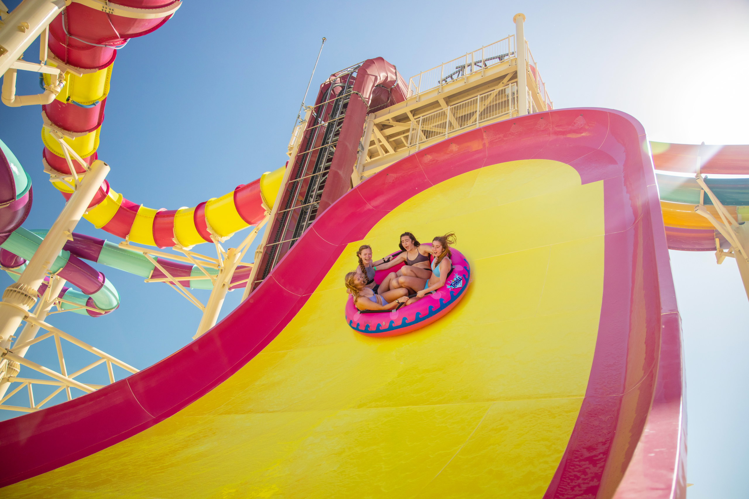 Pink and yellow Boomerango water slide with a raft high on the wall