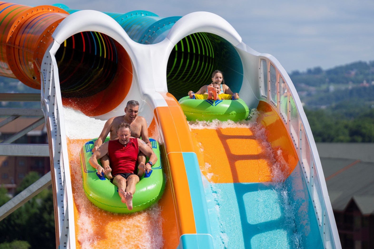 Riders on two inner tubes on water slide in water park