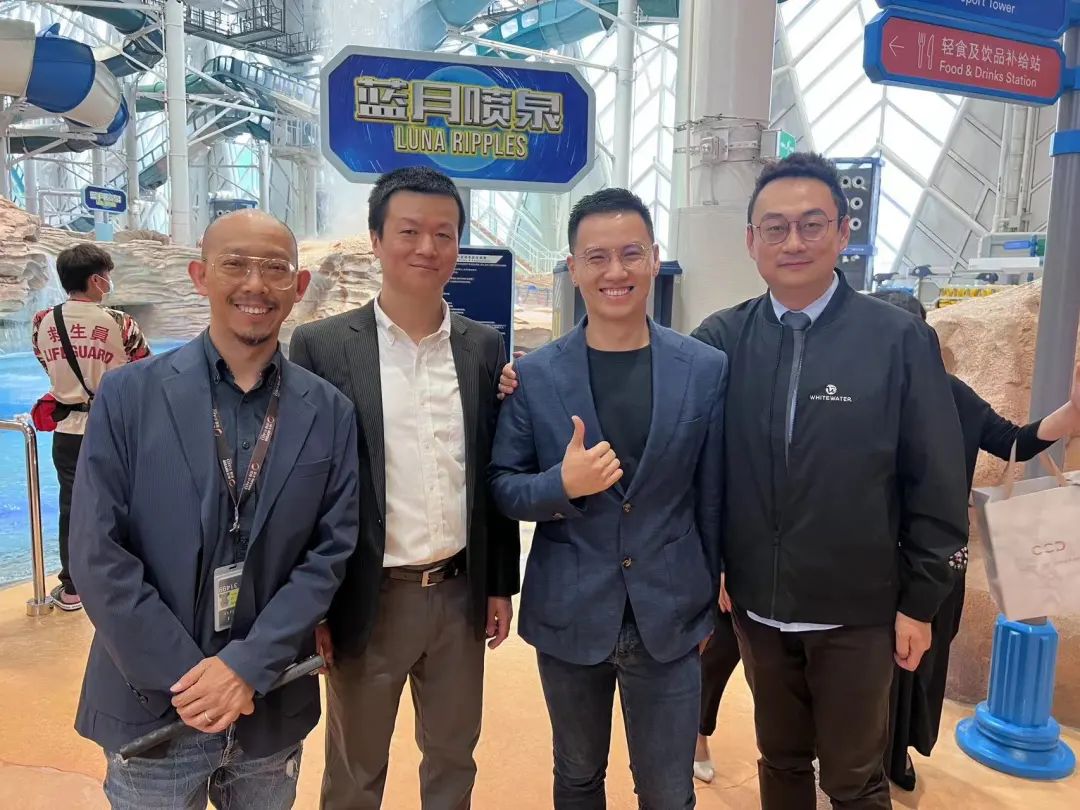 Four men posing inside indoor water park grand opening