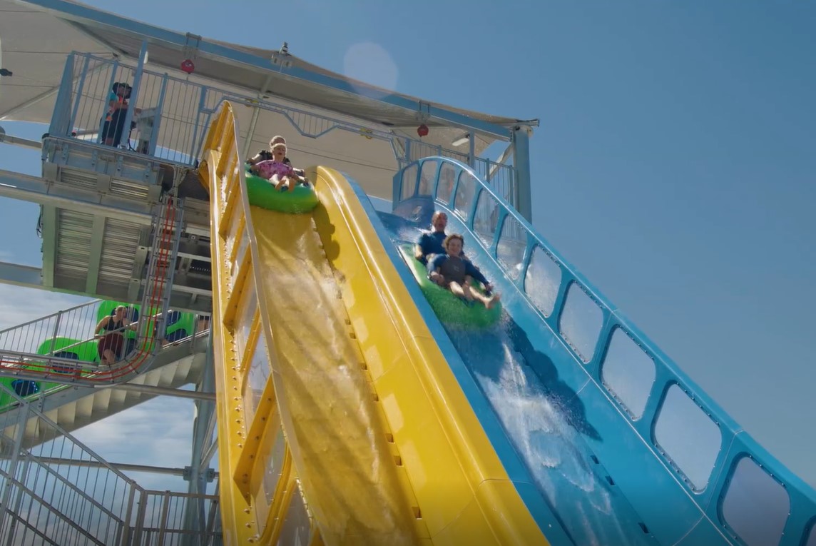 Four riders in two inner tubes going down a mega drop on a water coaster