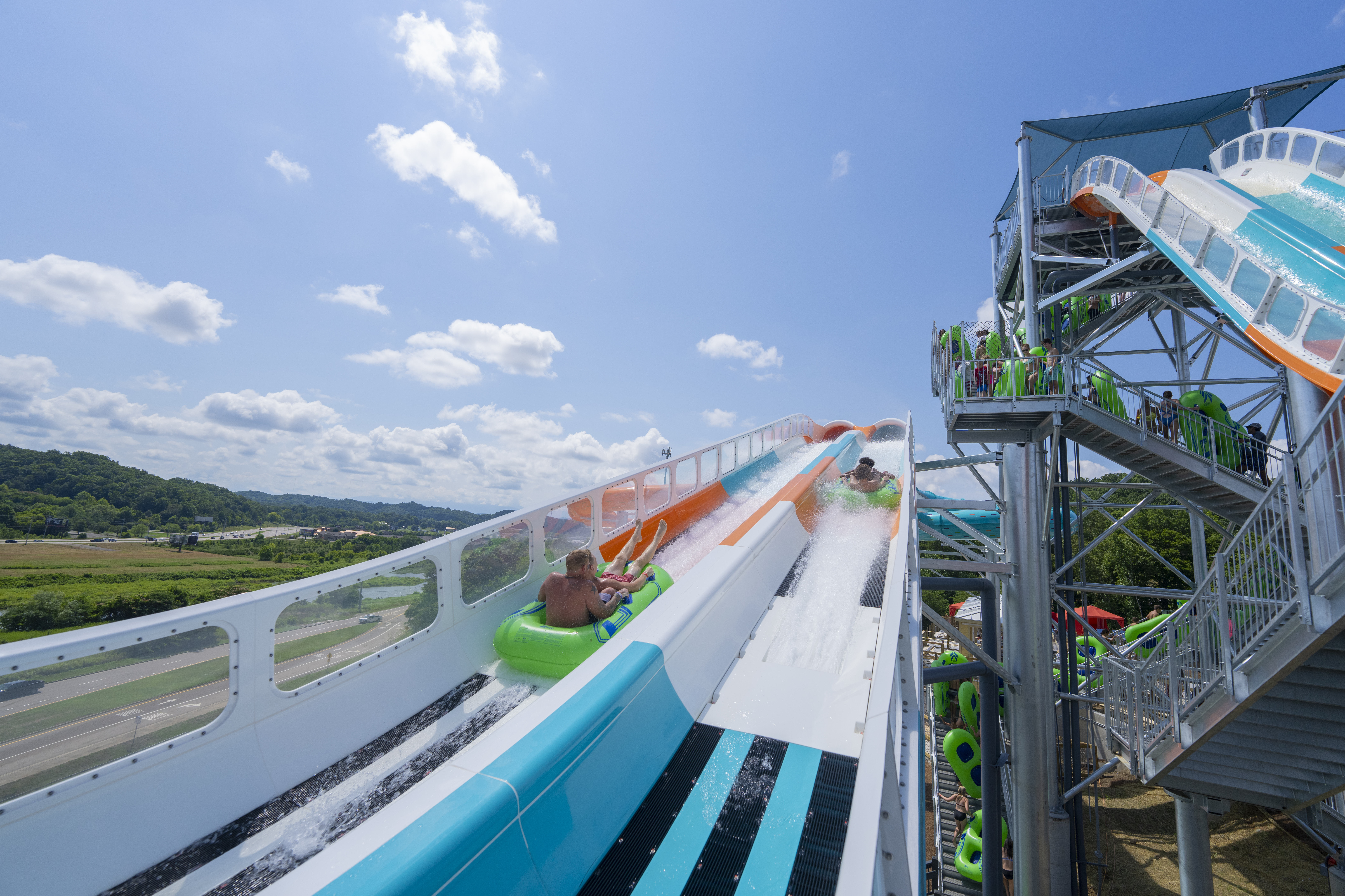 Riders in inner tubes going uphill on a side-by-side water coaster