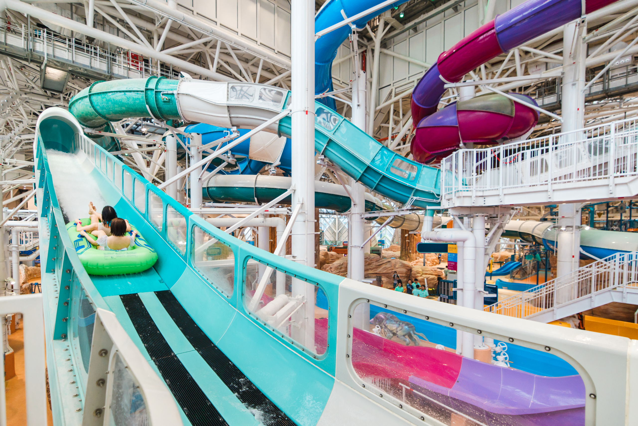 Indoor water park with water coaster heading uphill