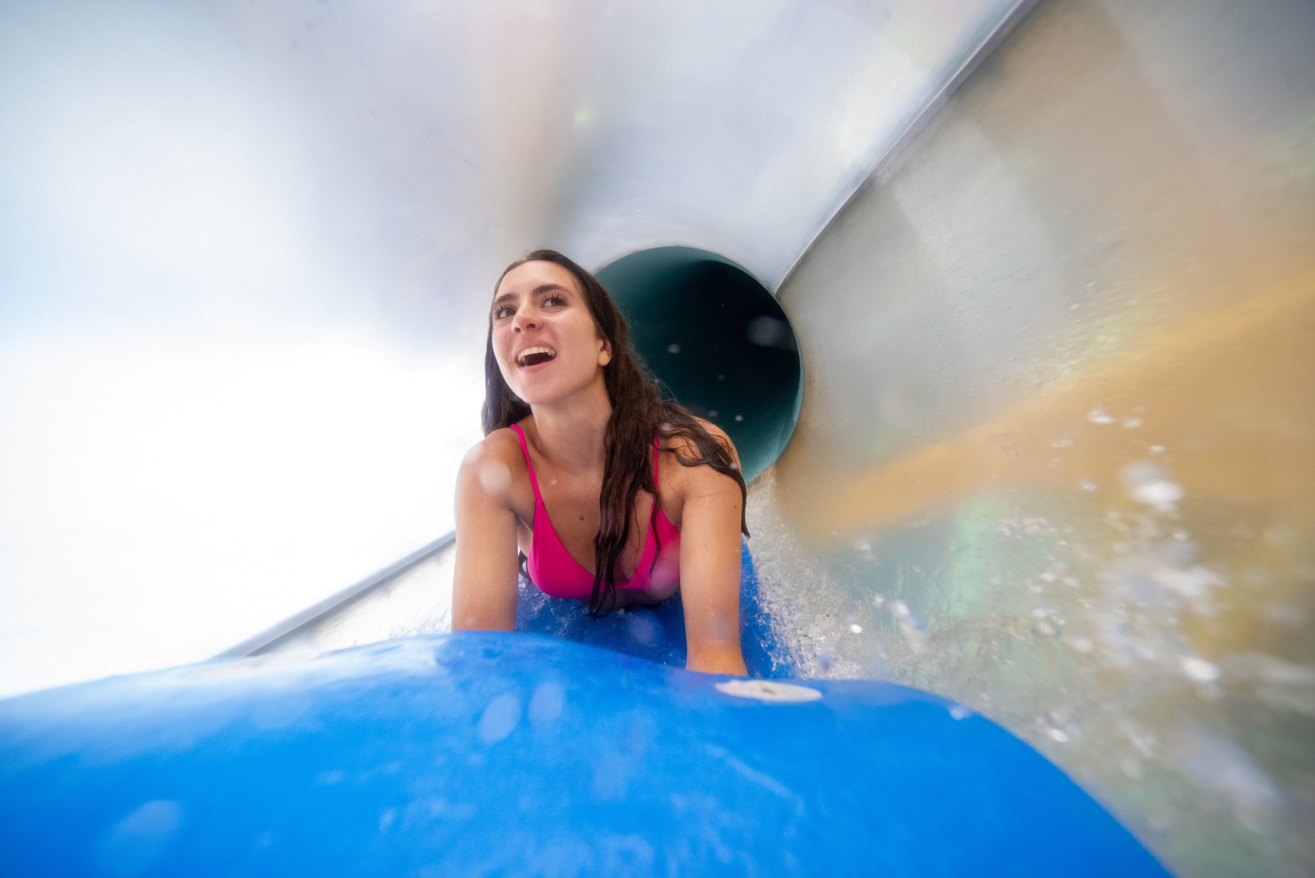 Woman on a mat inside water slide flume