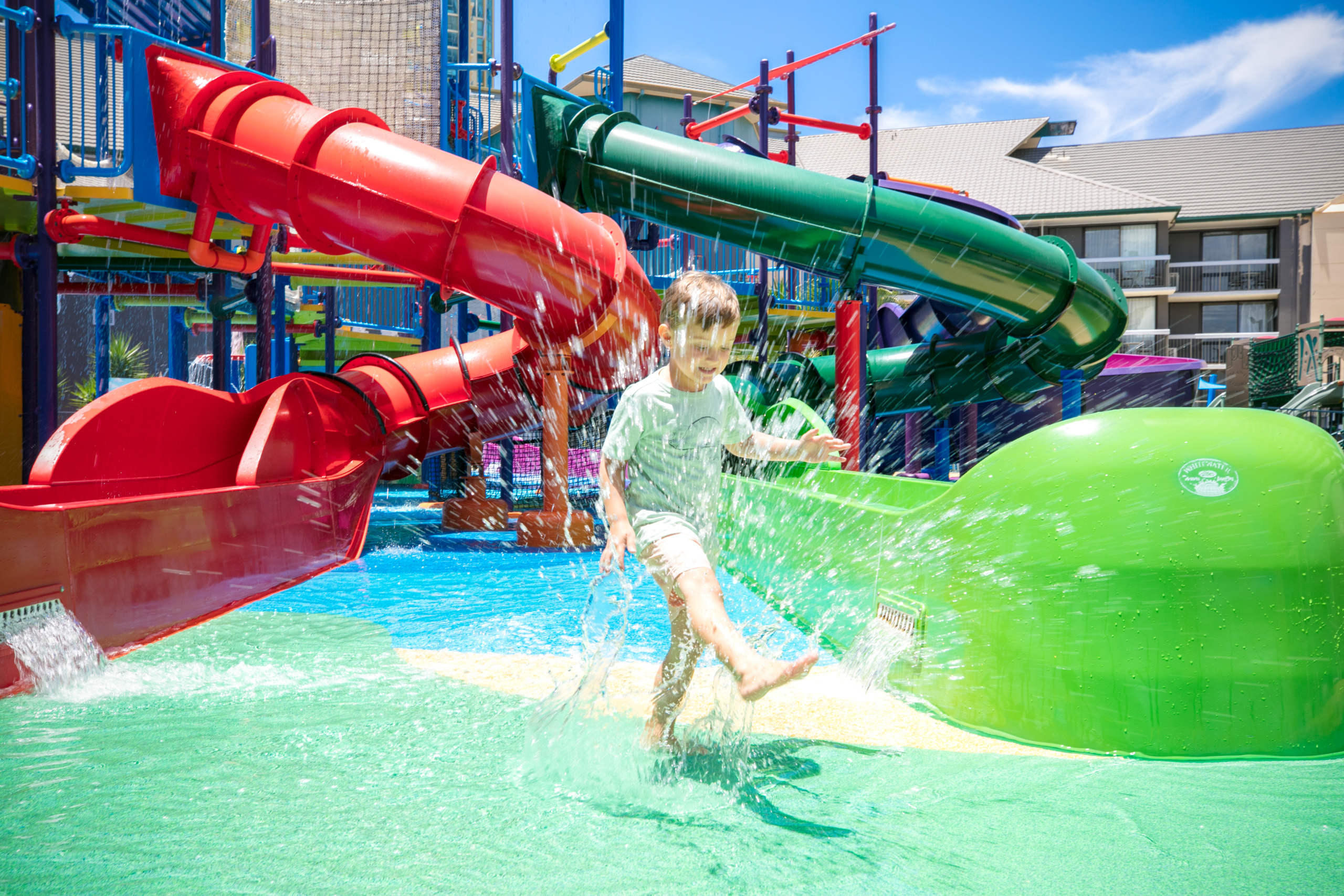 Child playing between water slides