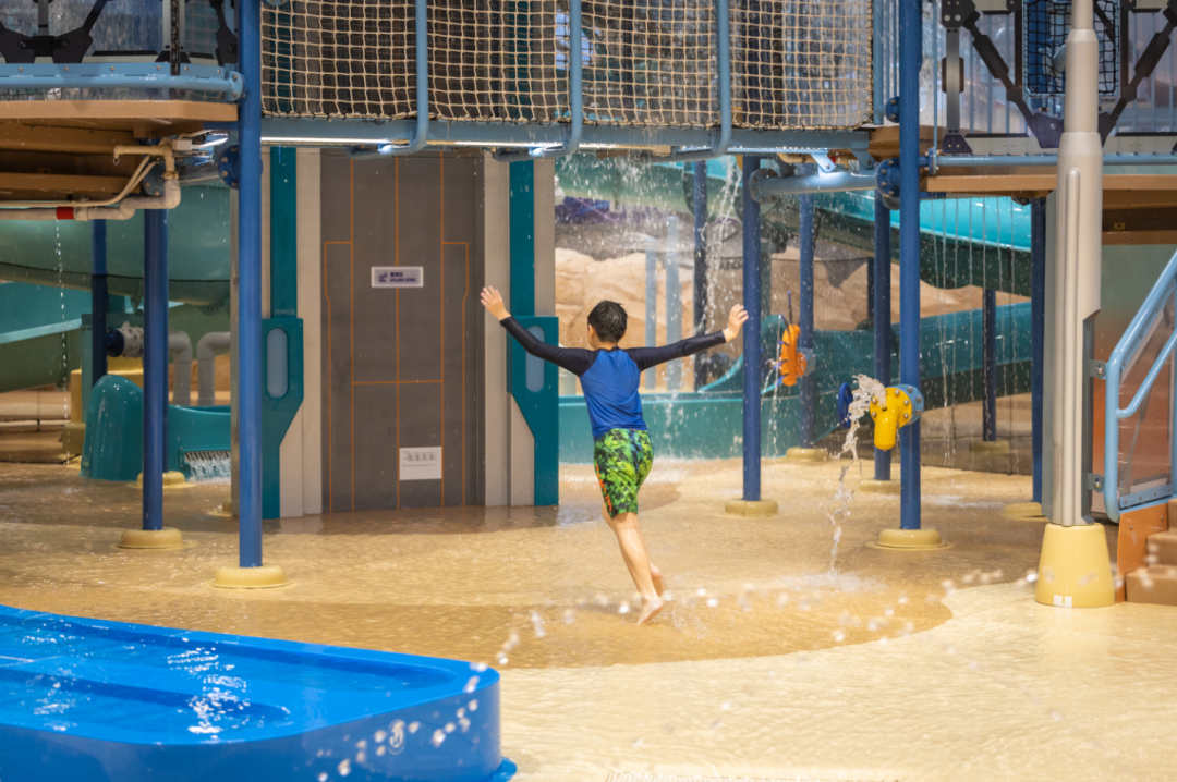 Little boy playing at an aquatic play area