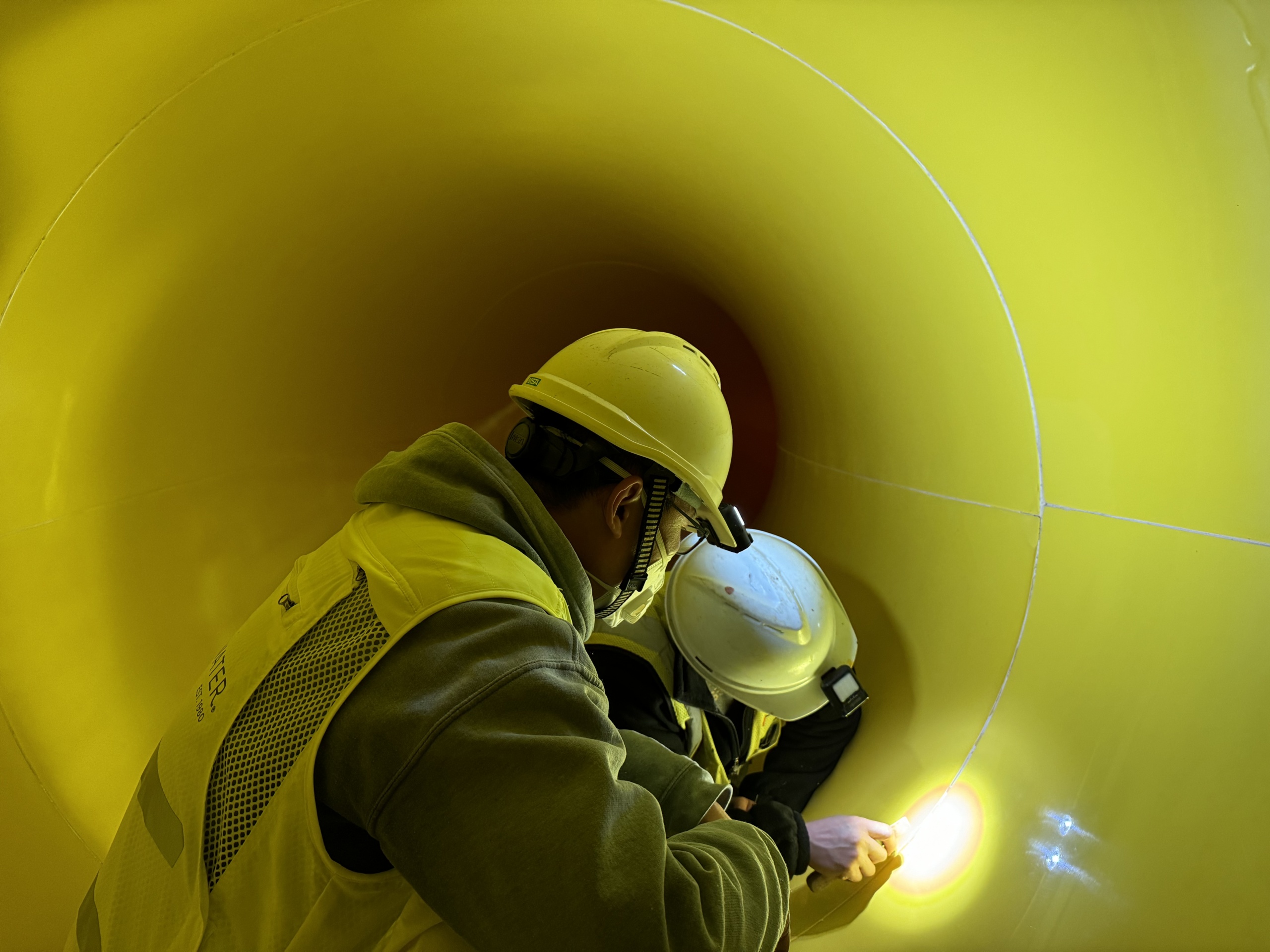 Two men inspecting a water slide flume