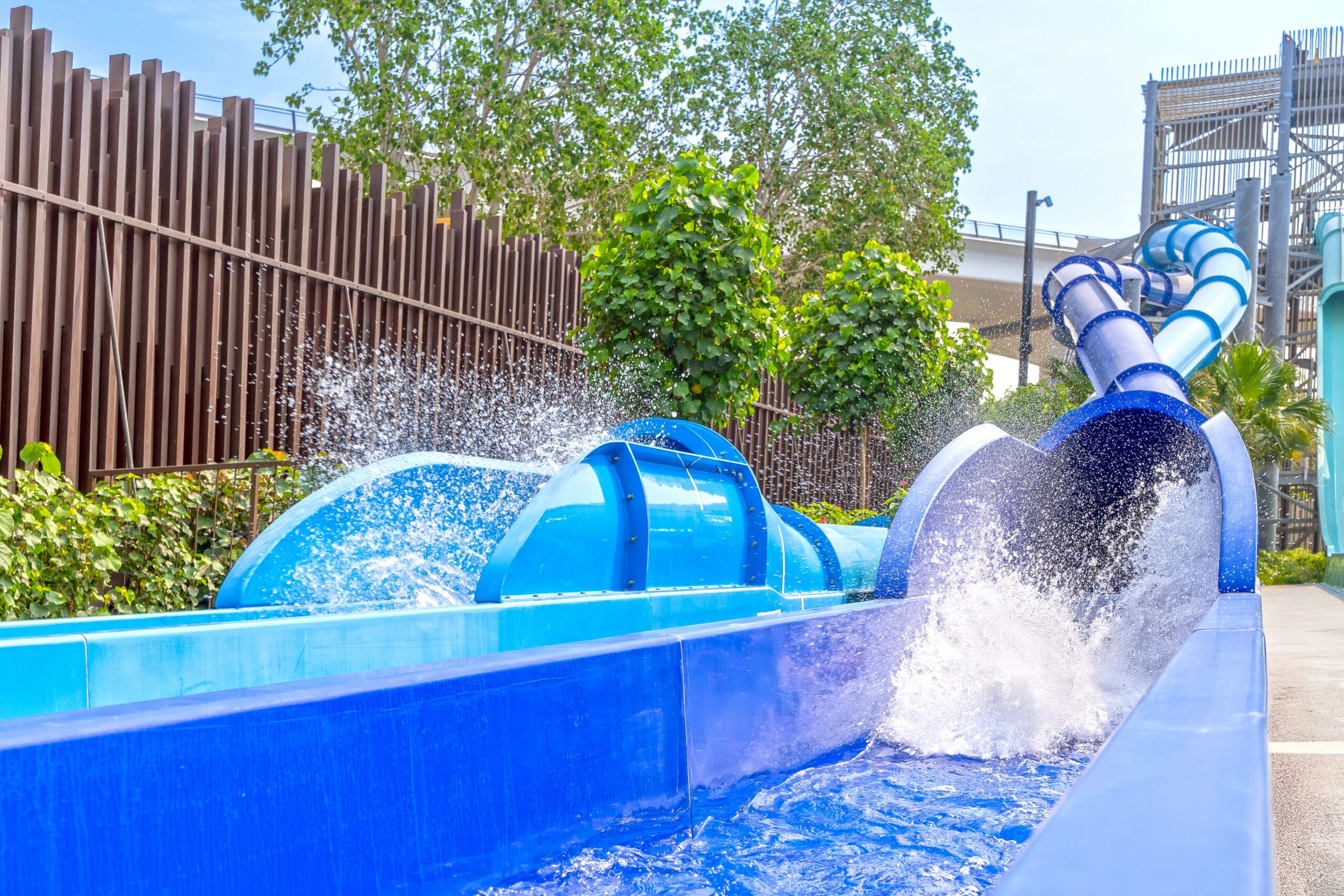Splashes coming out of two blue water slide flumes