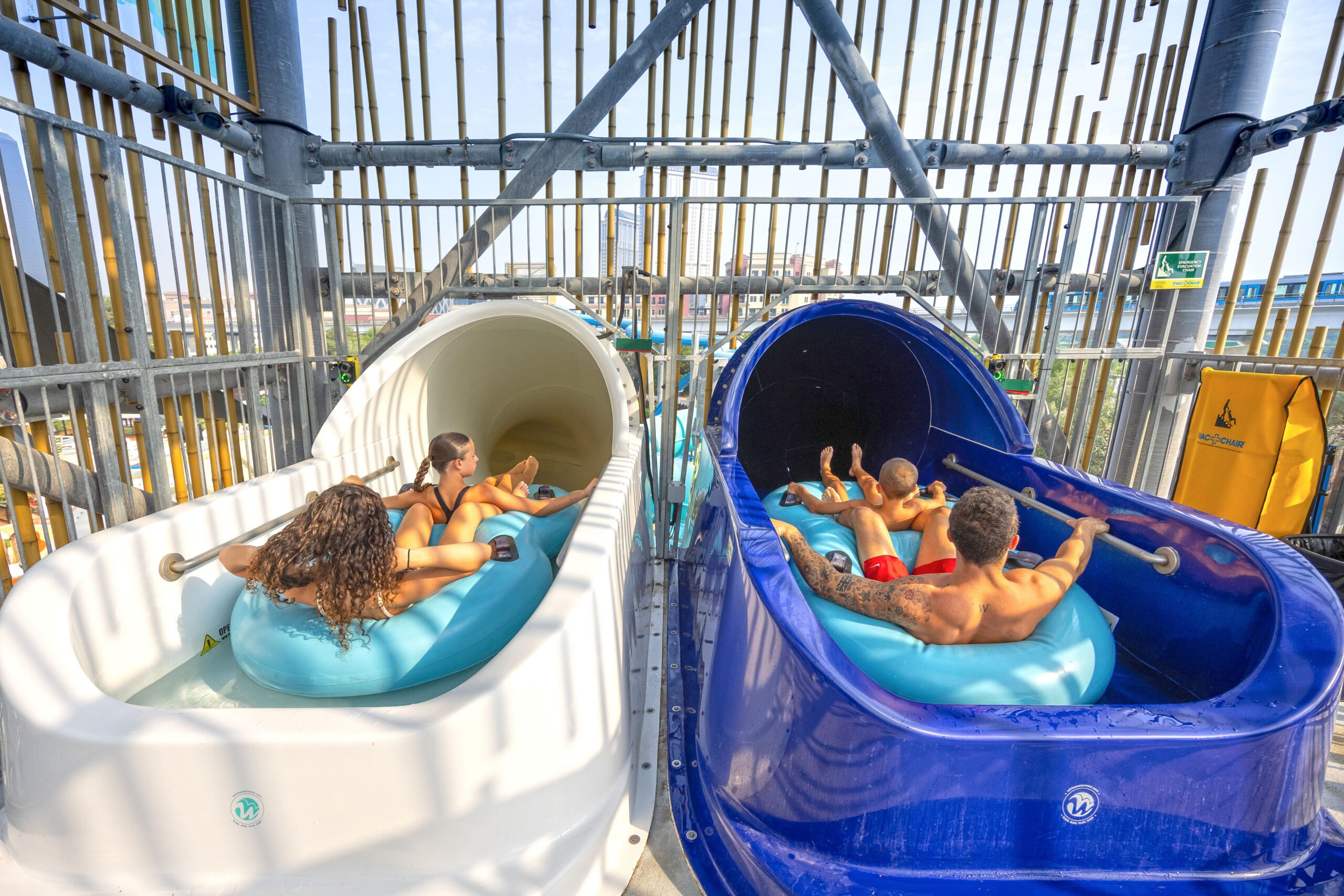 Riders in two inner tubes side by side ready to go down a water slide