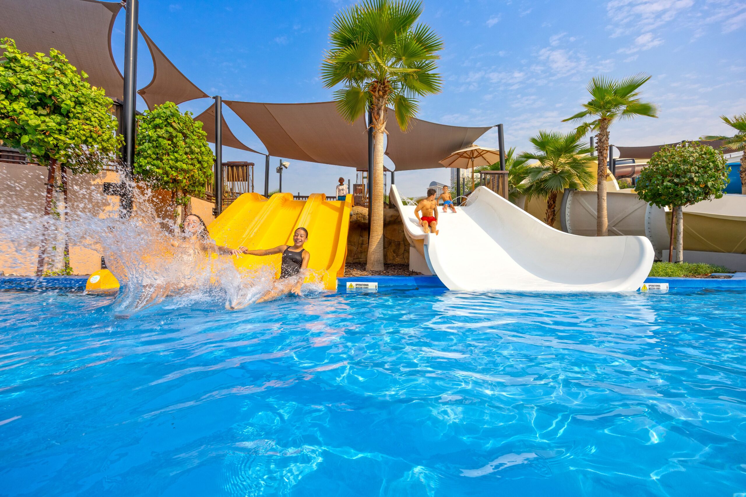 Children sliding into a pool