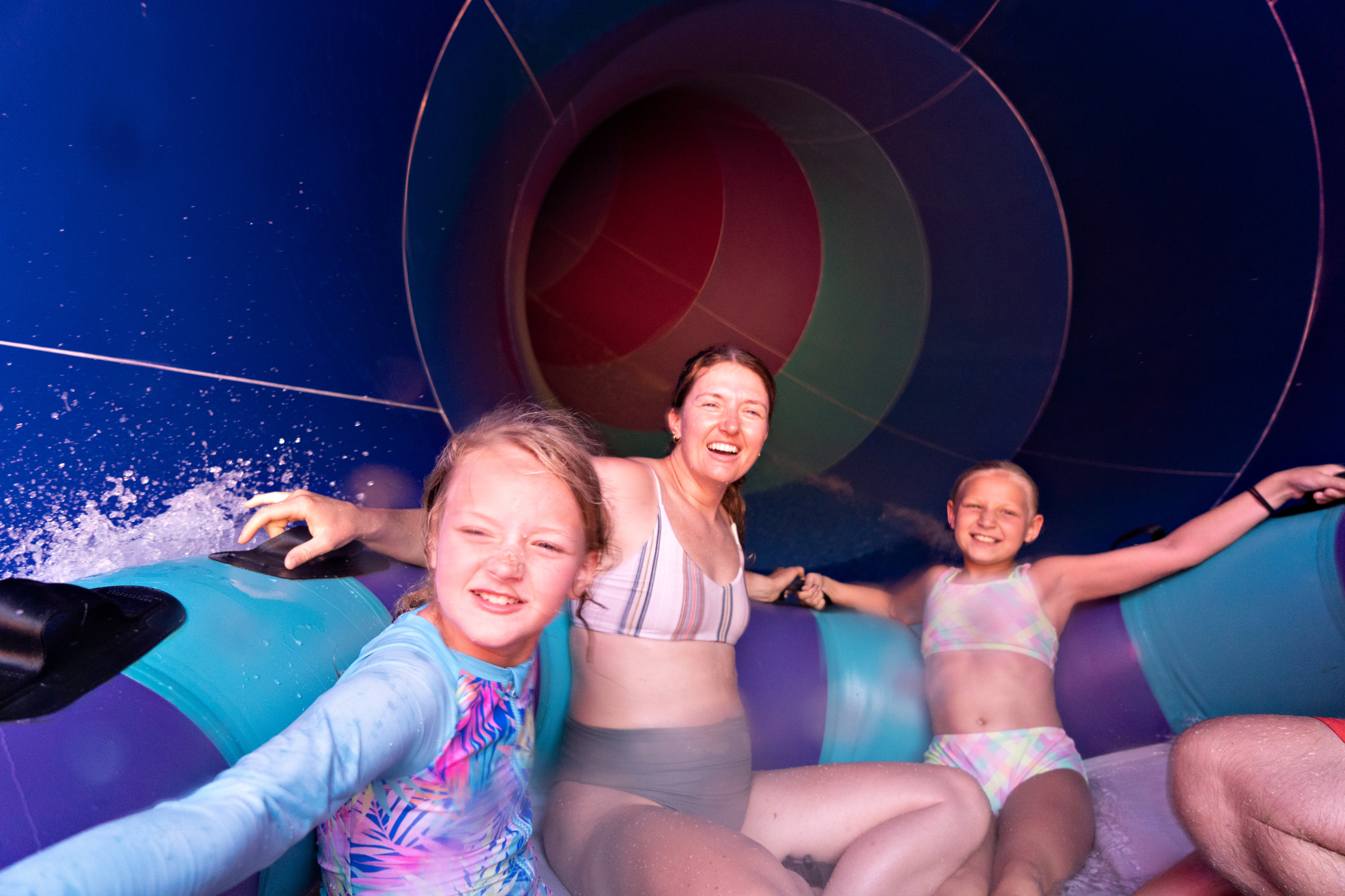 Young family of 3 racing down the Wall Runner in their family raft.