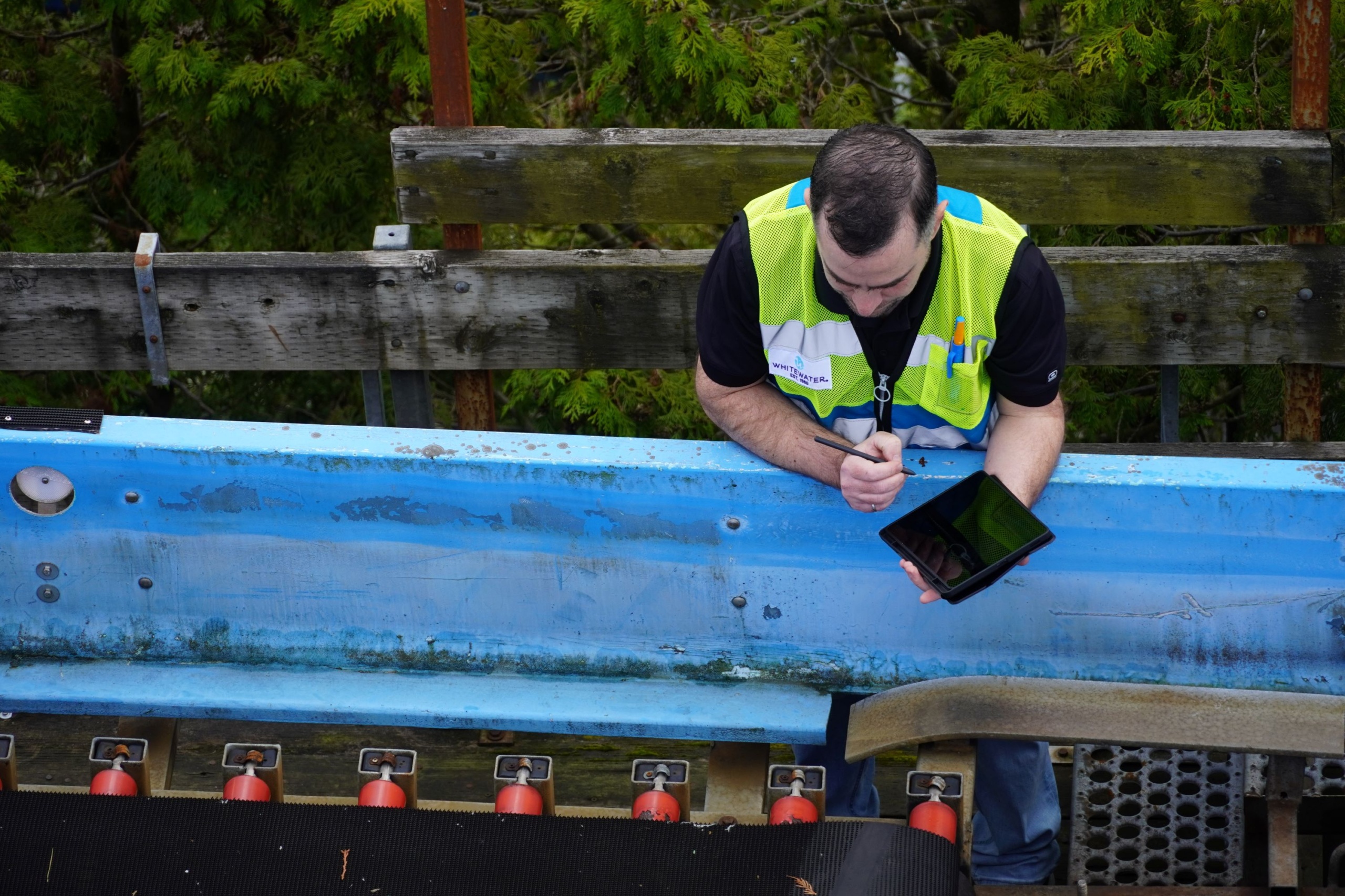 Man with a tablet recording water ride conditions.
