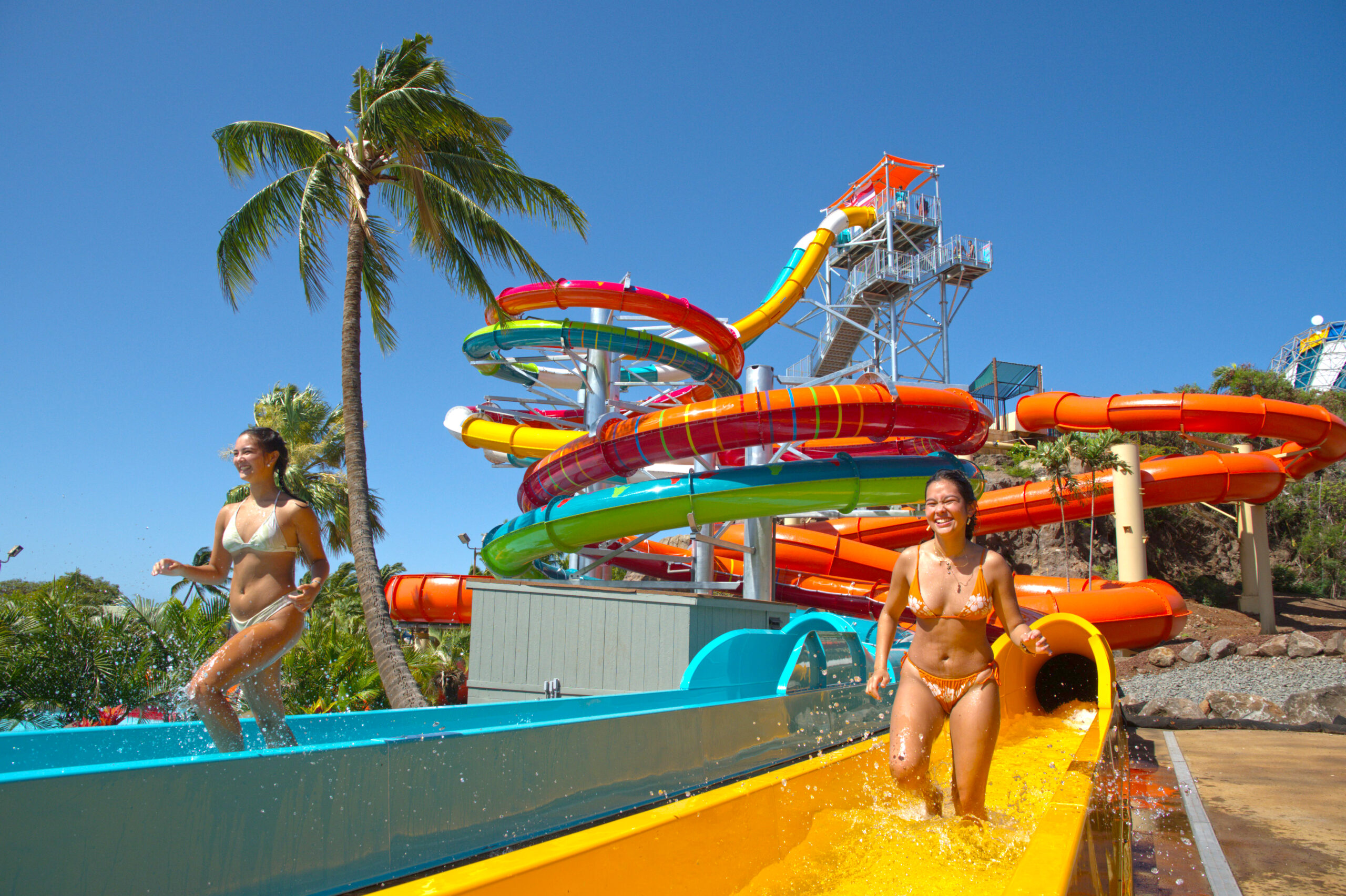 Two women in water slide runout lanes