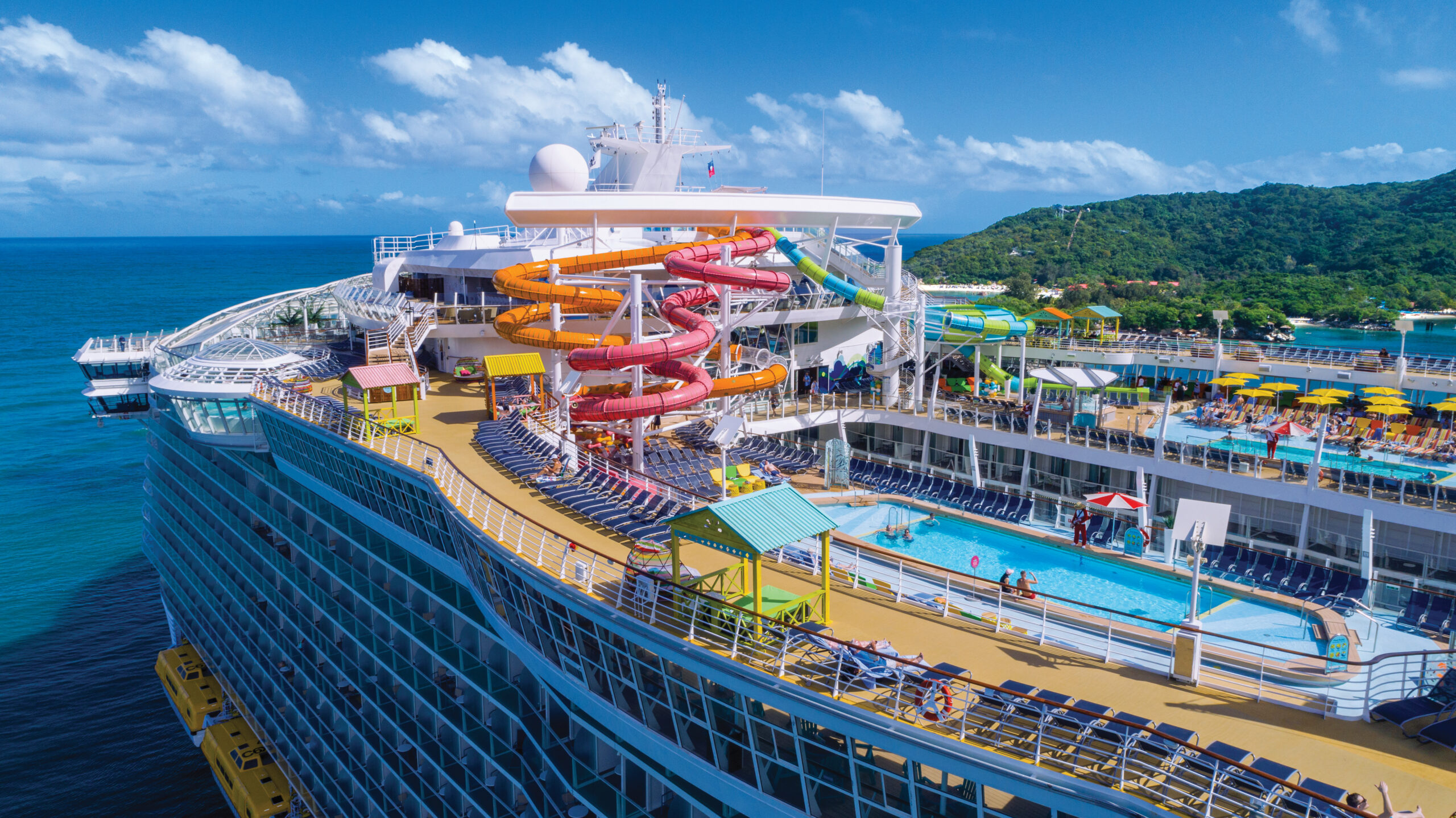 A cruise ship on a sunny day with lots of colourful water slides.