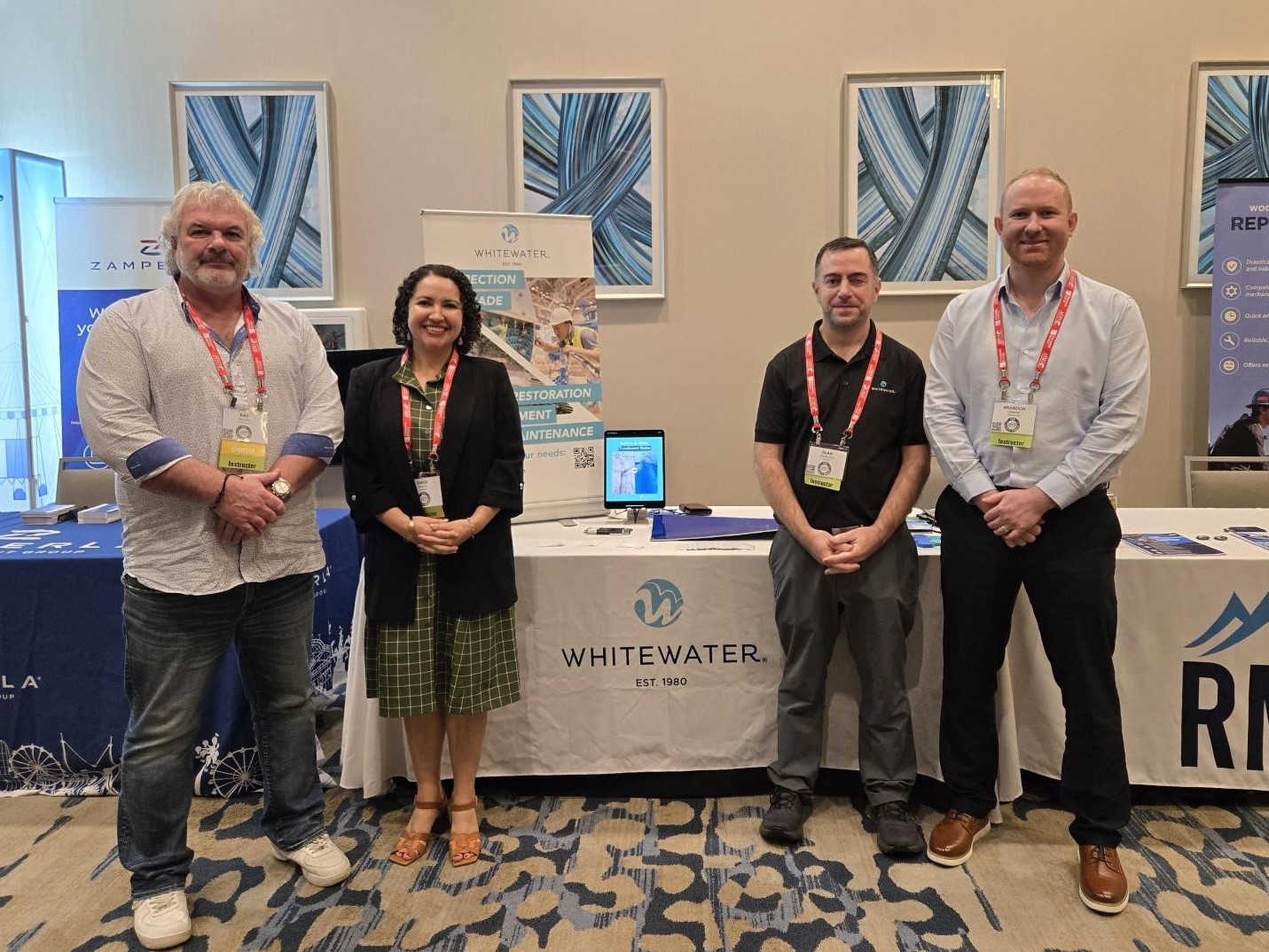 Four people standing in front of a table at AIMS International Safety Seminar