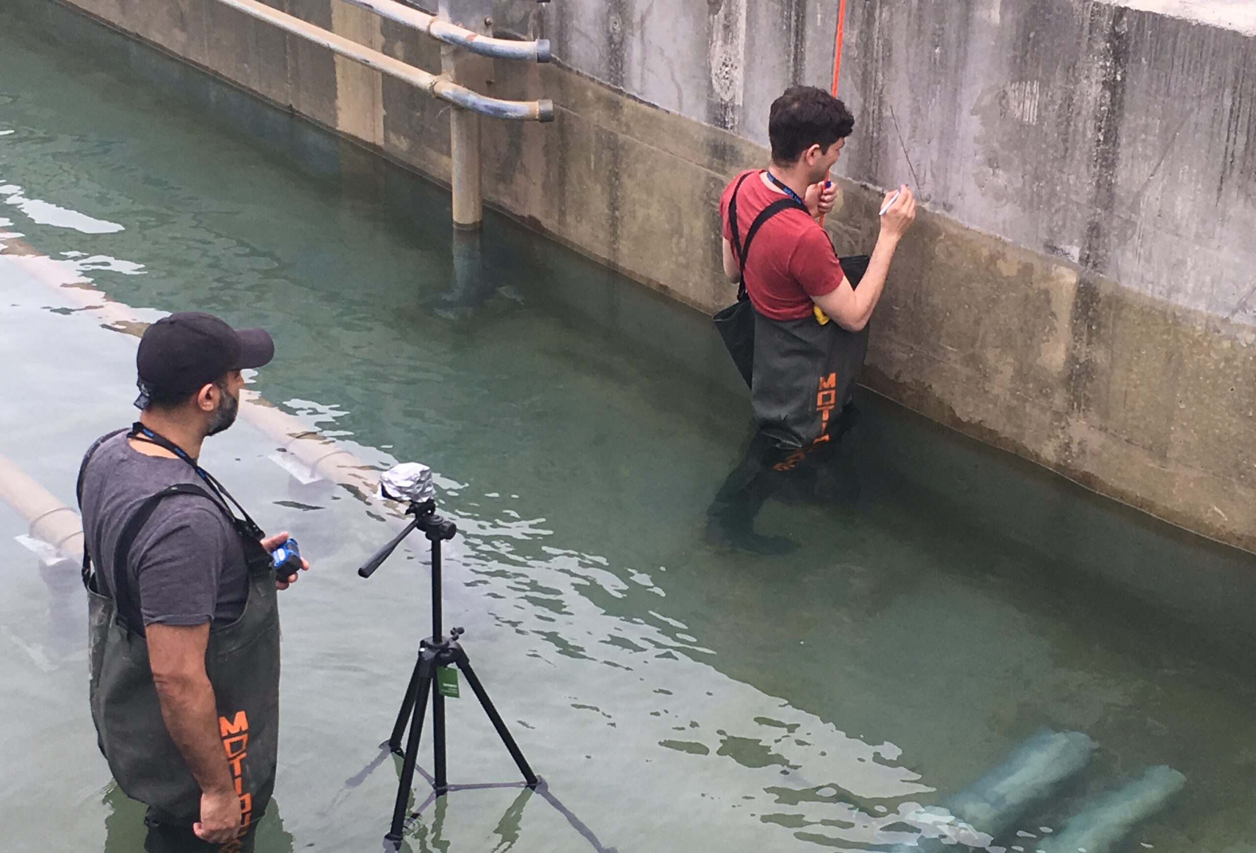 Two men inspecting a trough