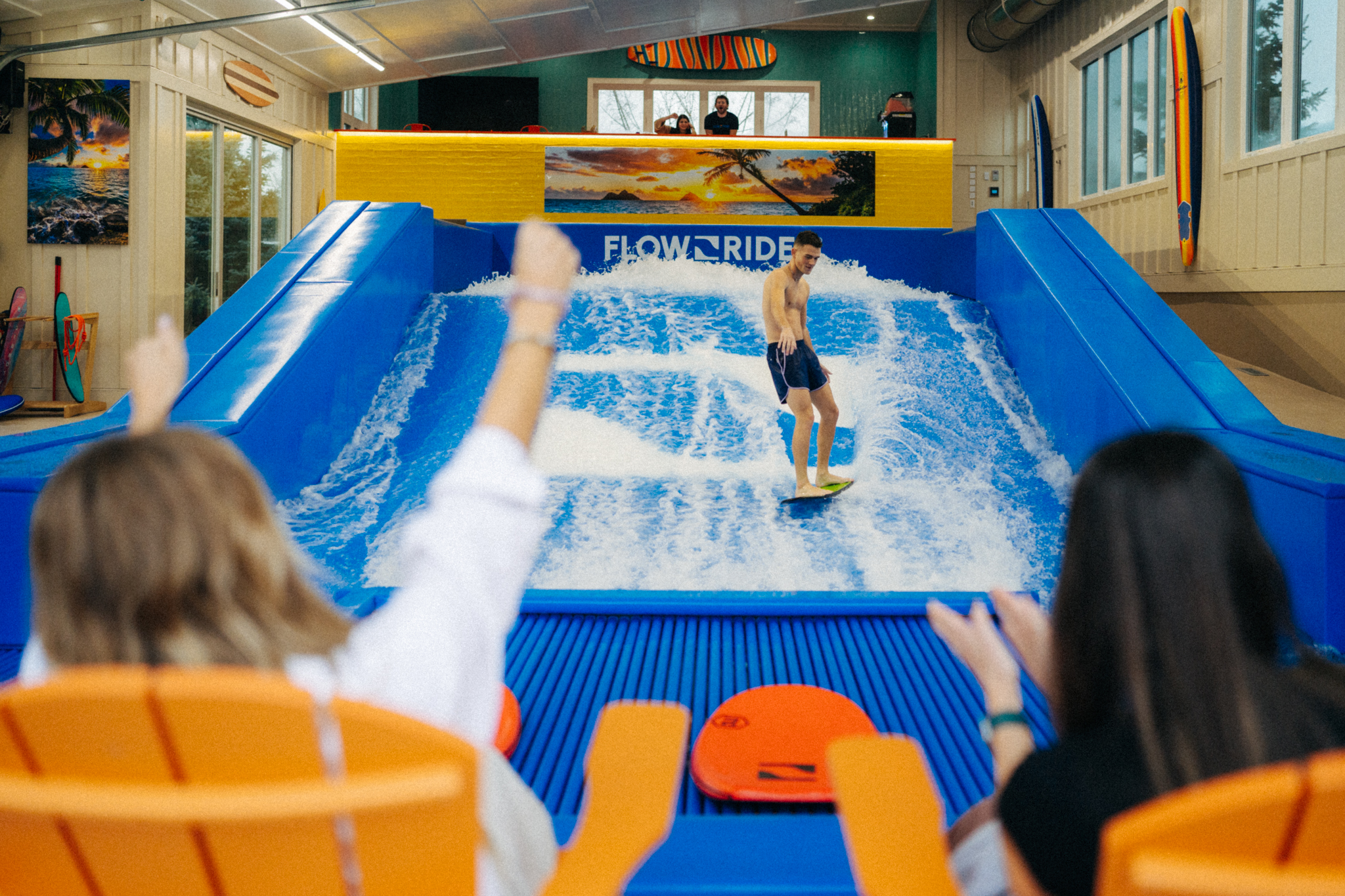 Guest sitting and watching a surfer on a FlowRider Single