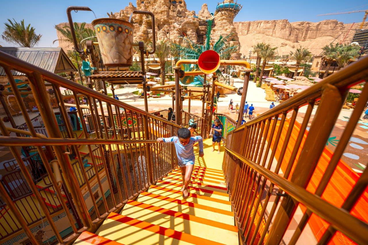A kid climbing up an aquatic play structure