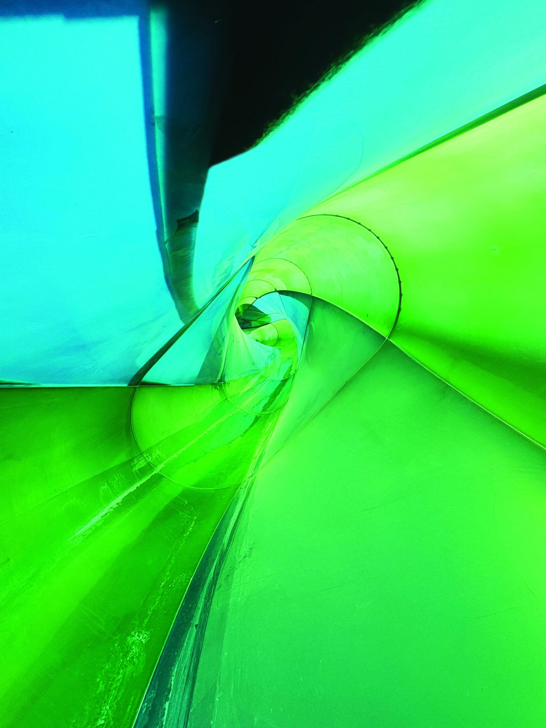 Inside a twisting blue and green water slide.