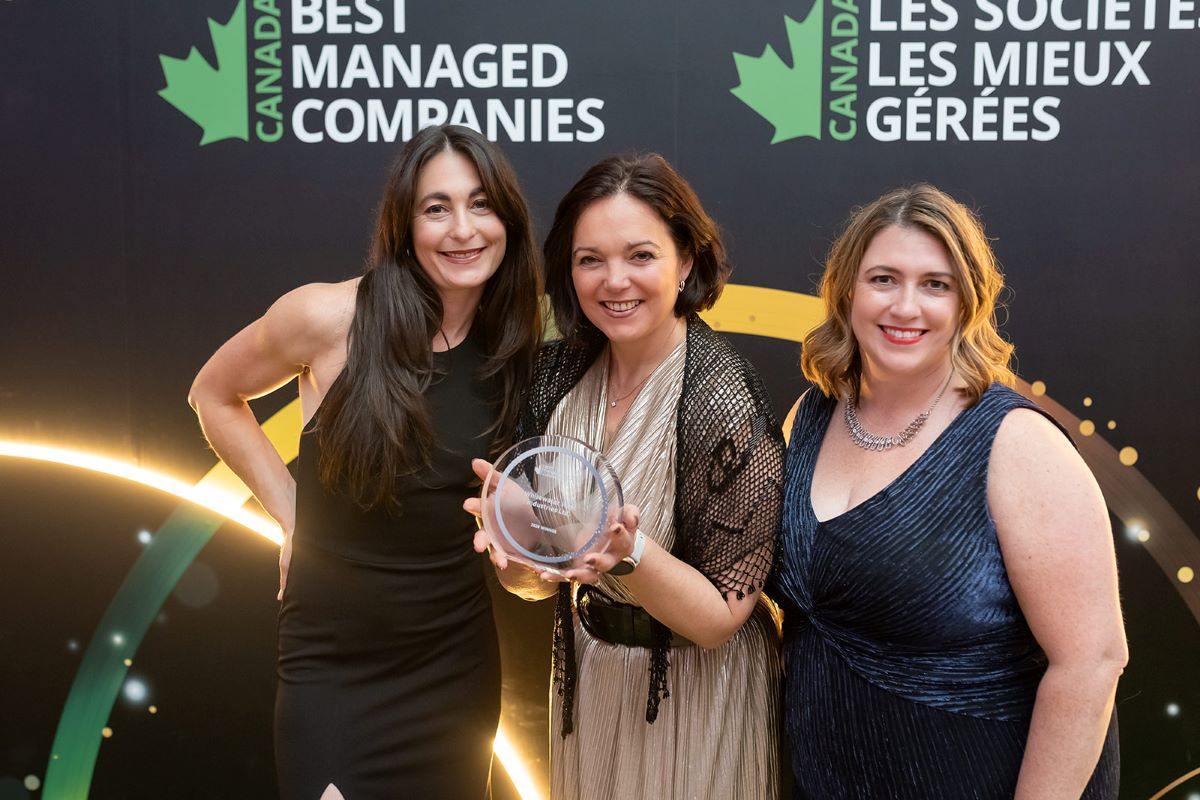 Three women holding an award