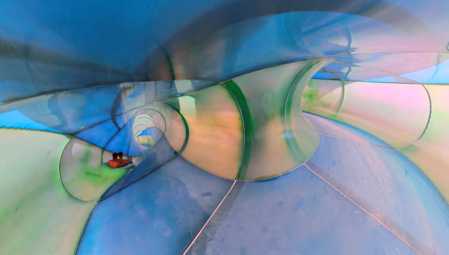 Riders in inner tube inside a twisting water slide flume