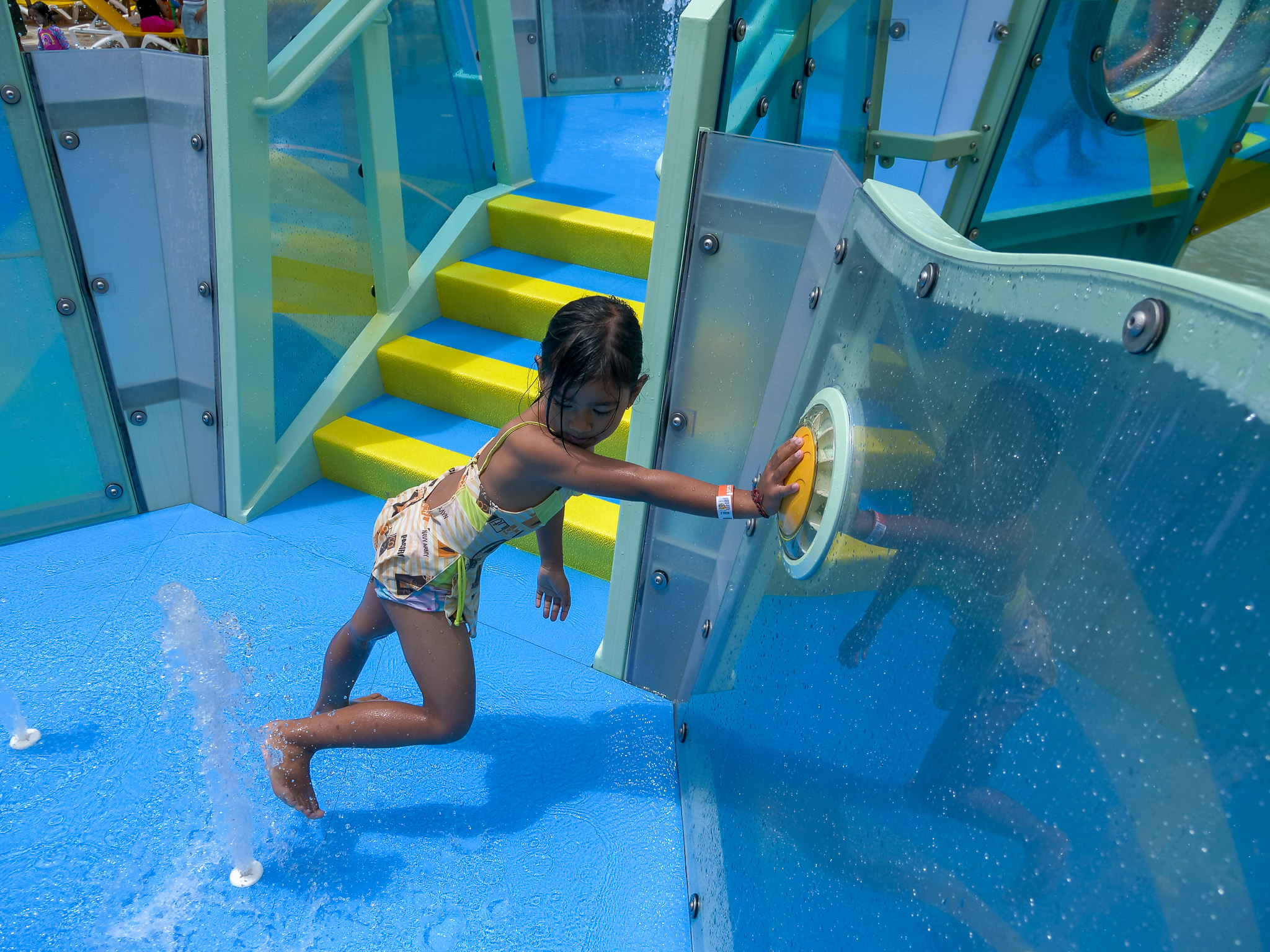 Girl playing with a handprint activator on an aquatic play structure