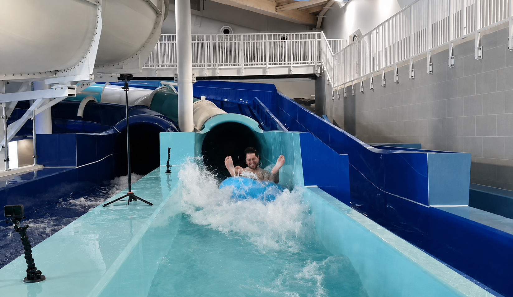 Man on an inner tube on a water slide indoor