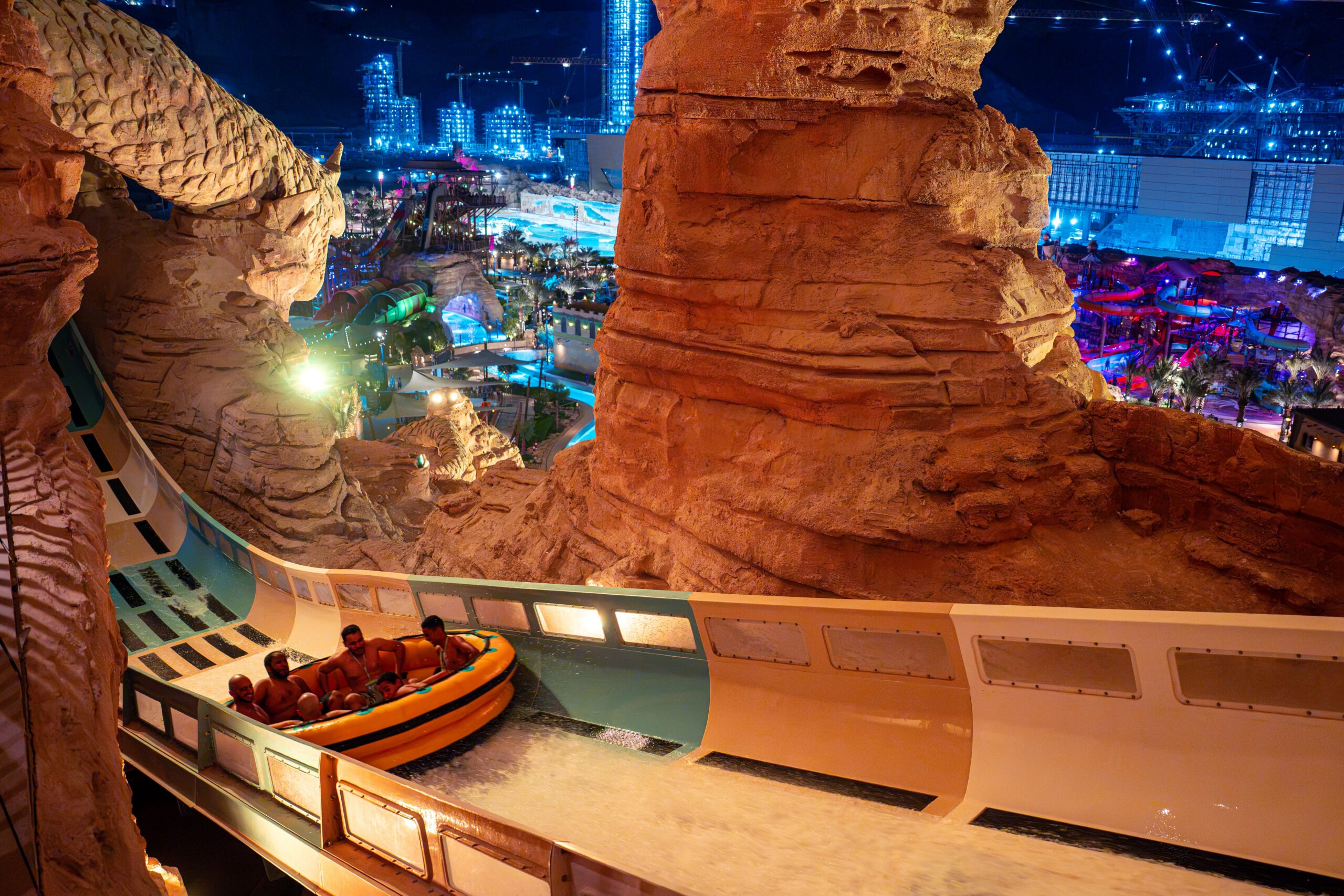 A family coaster raft at a water park at night in the middle of a desert