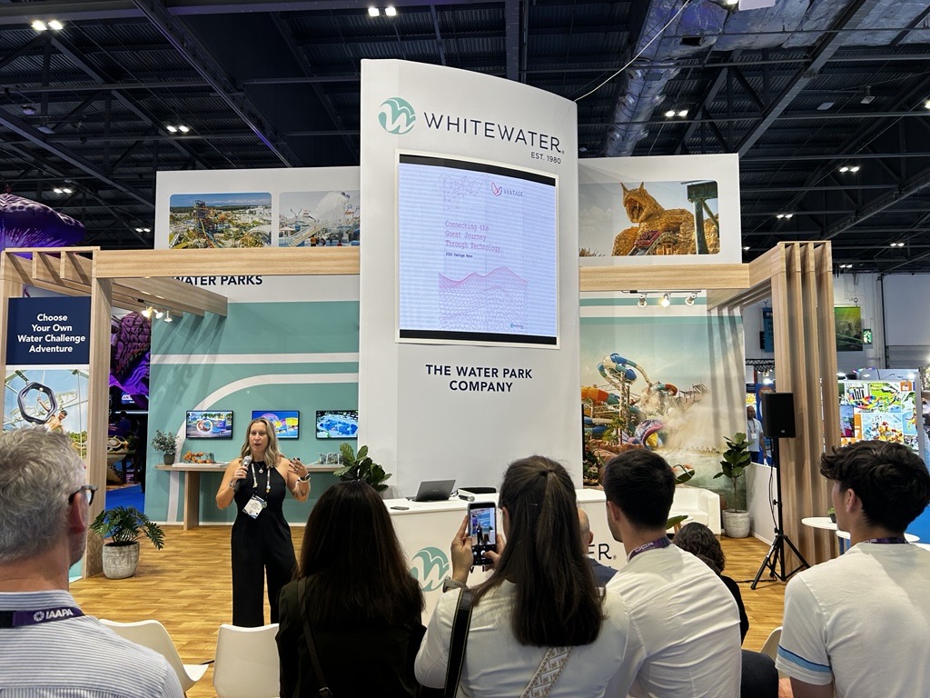 A woman giving a presentation at a press conference at a trade show
