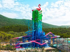 A tall water slide tower with a pink flamingo on top