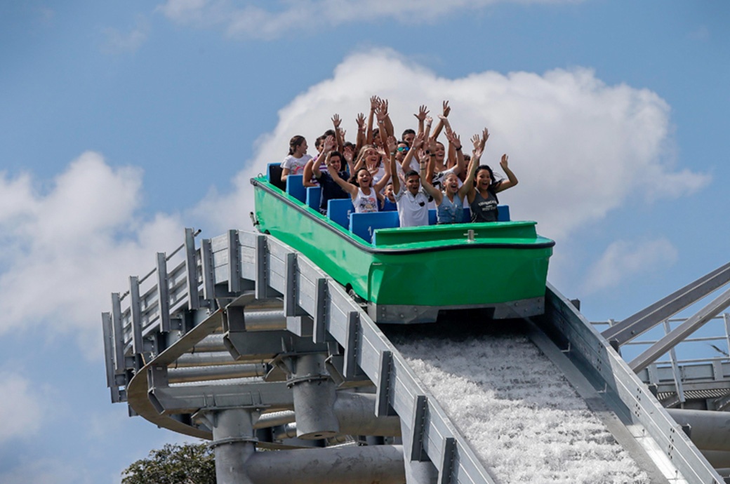 People on water ride vehicle about to go down a drop